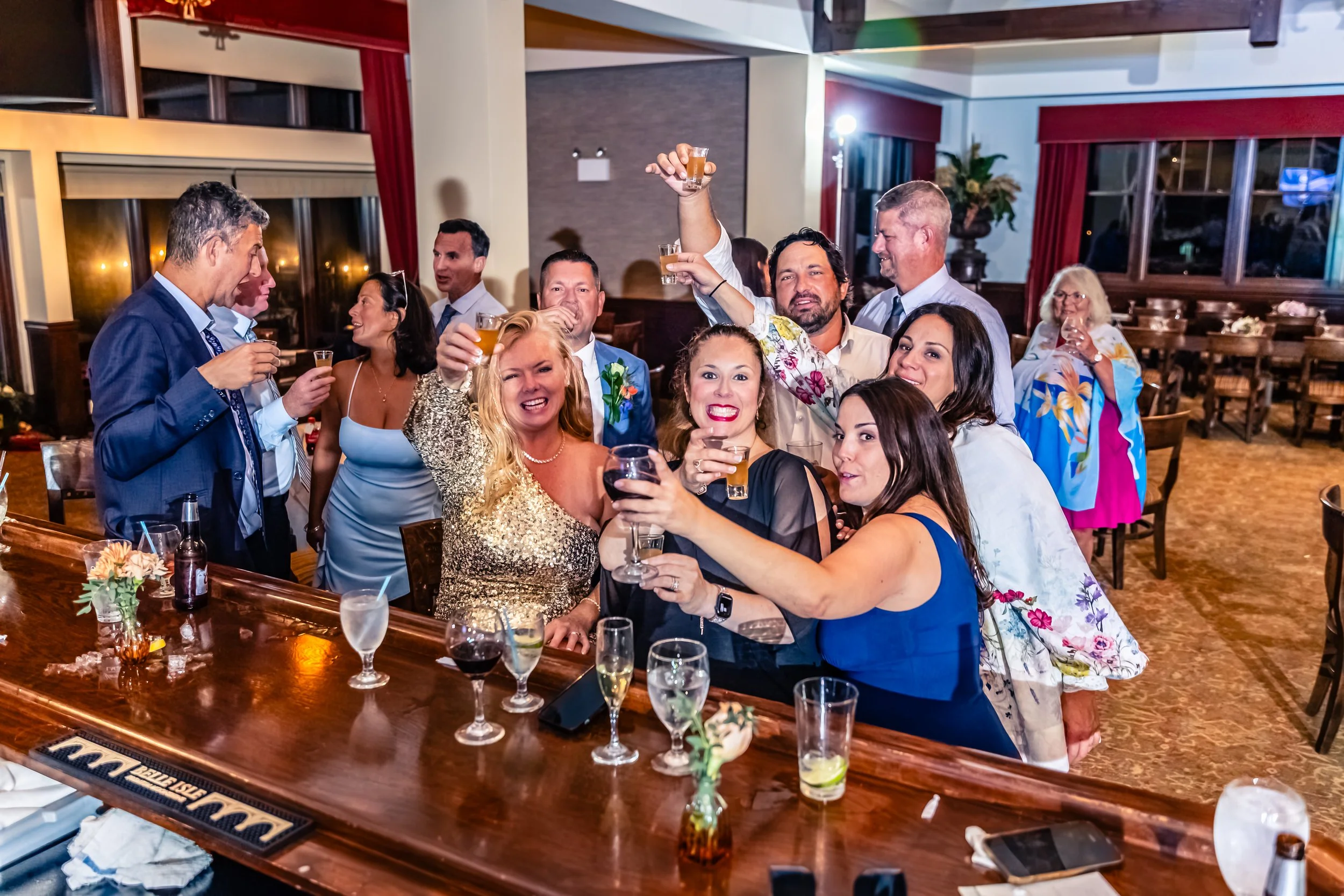 Group of people celebrating with drinks at a party or wedding reception in a banquet hall.