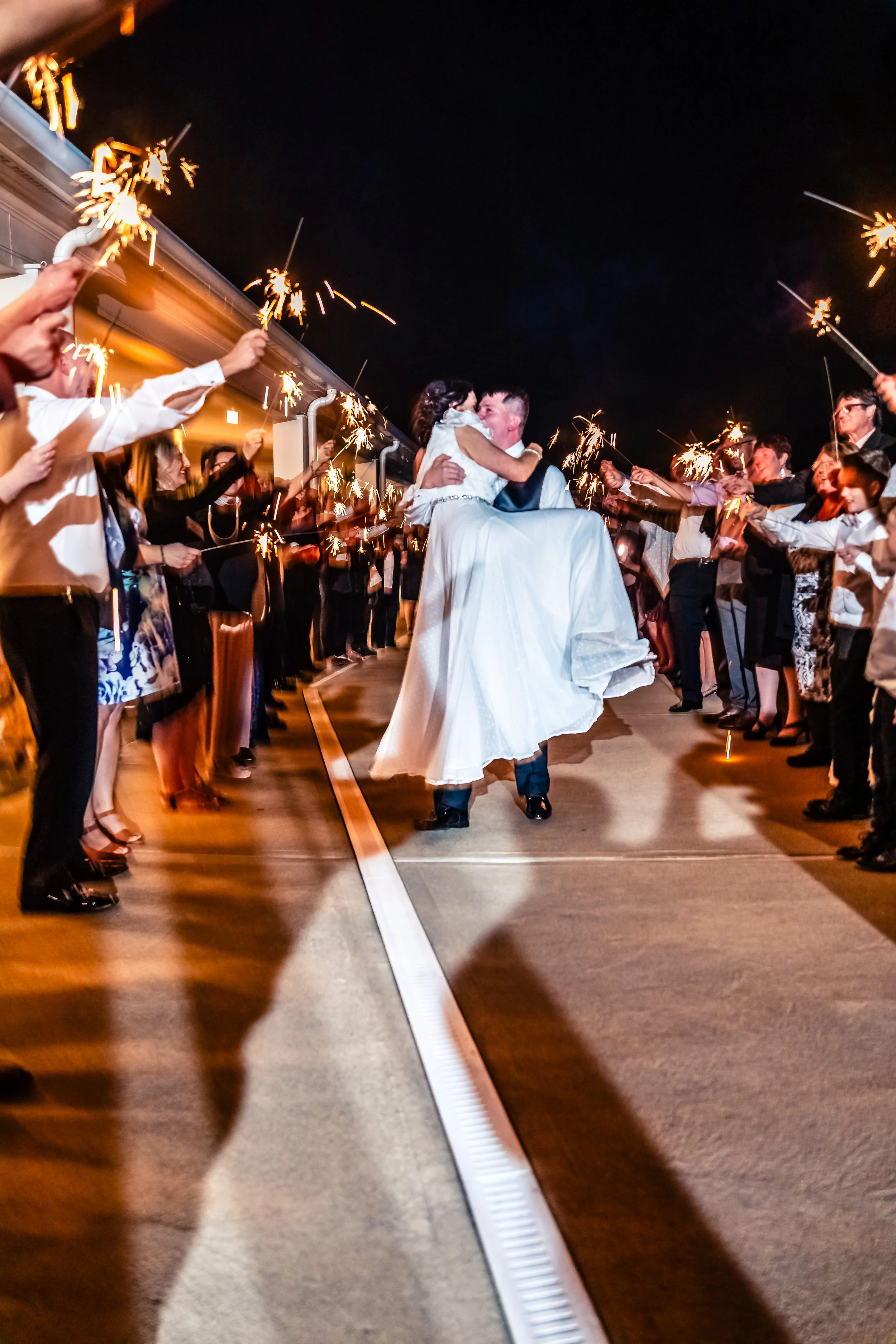young couple groom lifting bride, wedding, night shot, sprinkler sendoff, Phoenixville, Rivercrest Golf and Country Club, Schwenksville, Pennsylvania