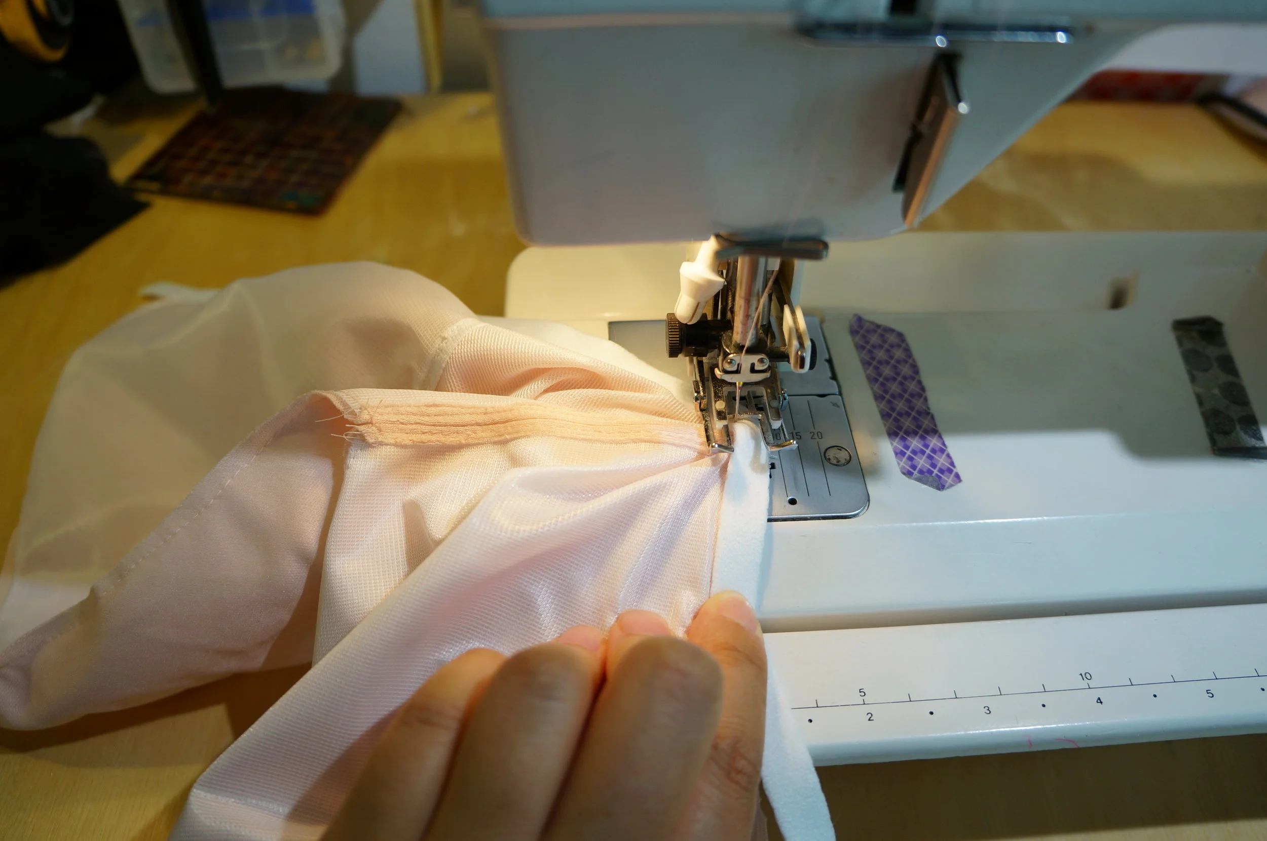 Stopped in the middle with needle down and presser foot up, rearrange fabric so second cup is smooth.