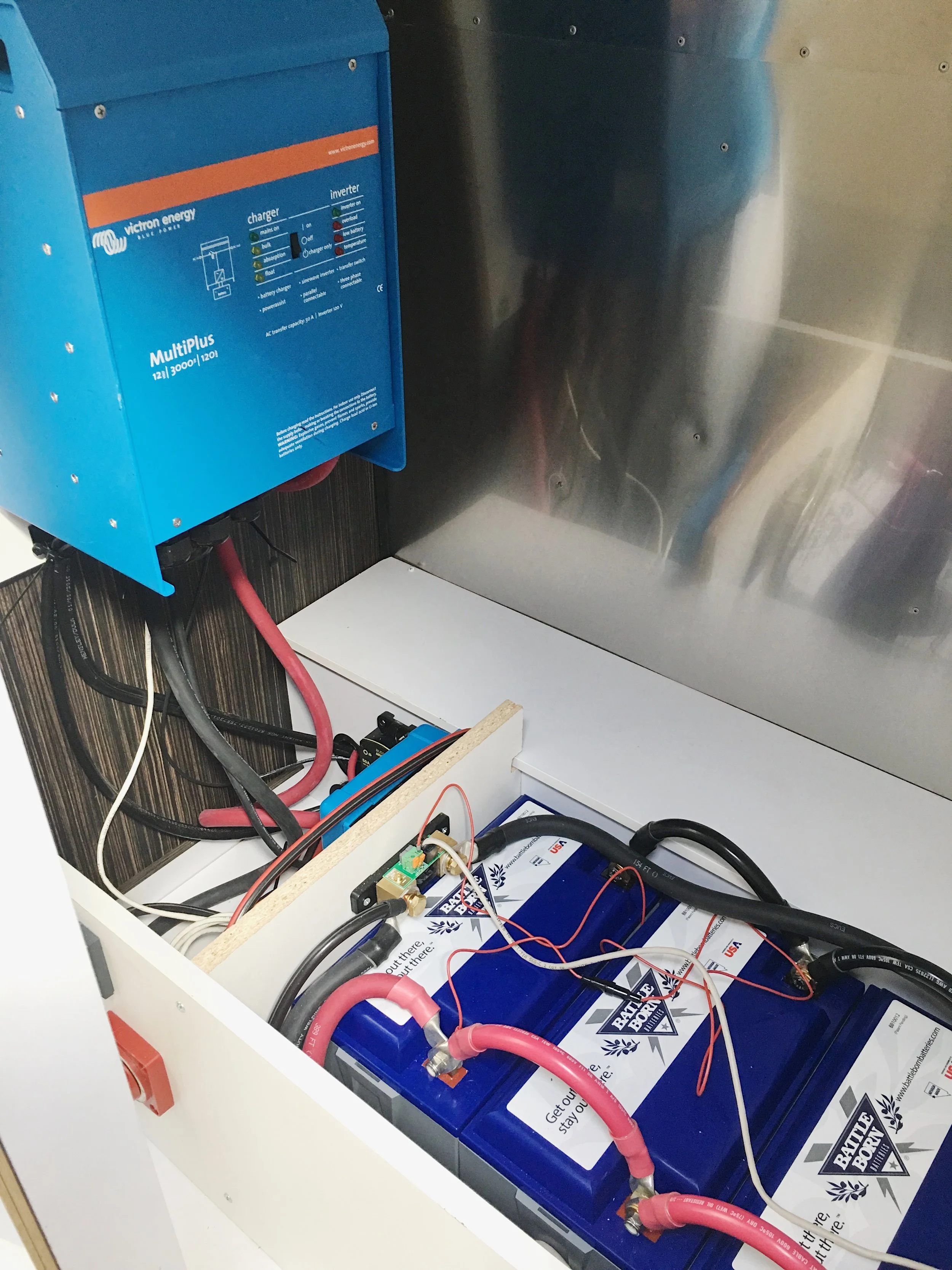 Inverter mounted before final wiring. Notice the shunt mounted by the batteries. All negative lines connect to the shunt so it can measure all electricity used. This is crucial to measuring the state of charge in your batteries.