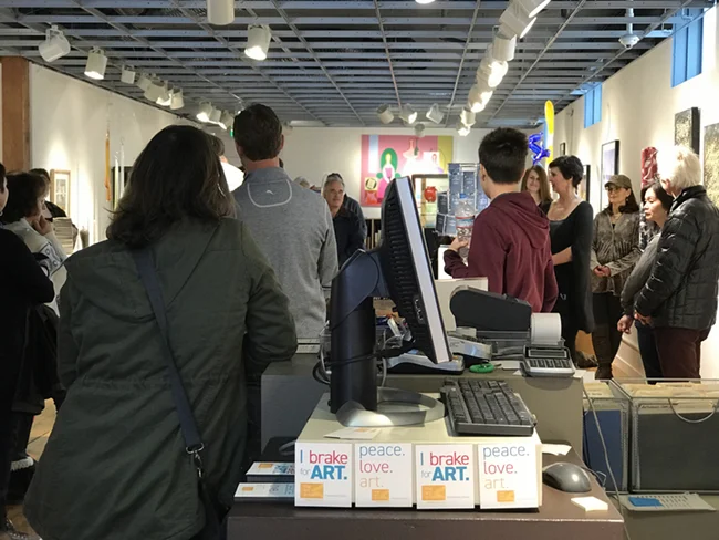 Holly Ballard Martz, shown fourth from right, discusses her show with gallery visitors.