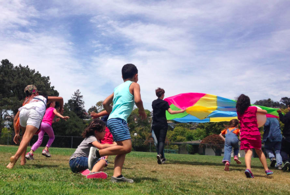 Kids play with a parachute at Rainbow Day Camp in El Cerrito. (Photo: Sandra Collins)
