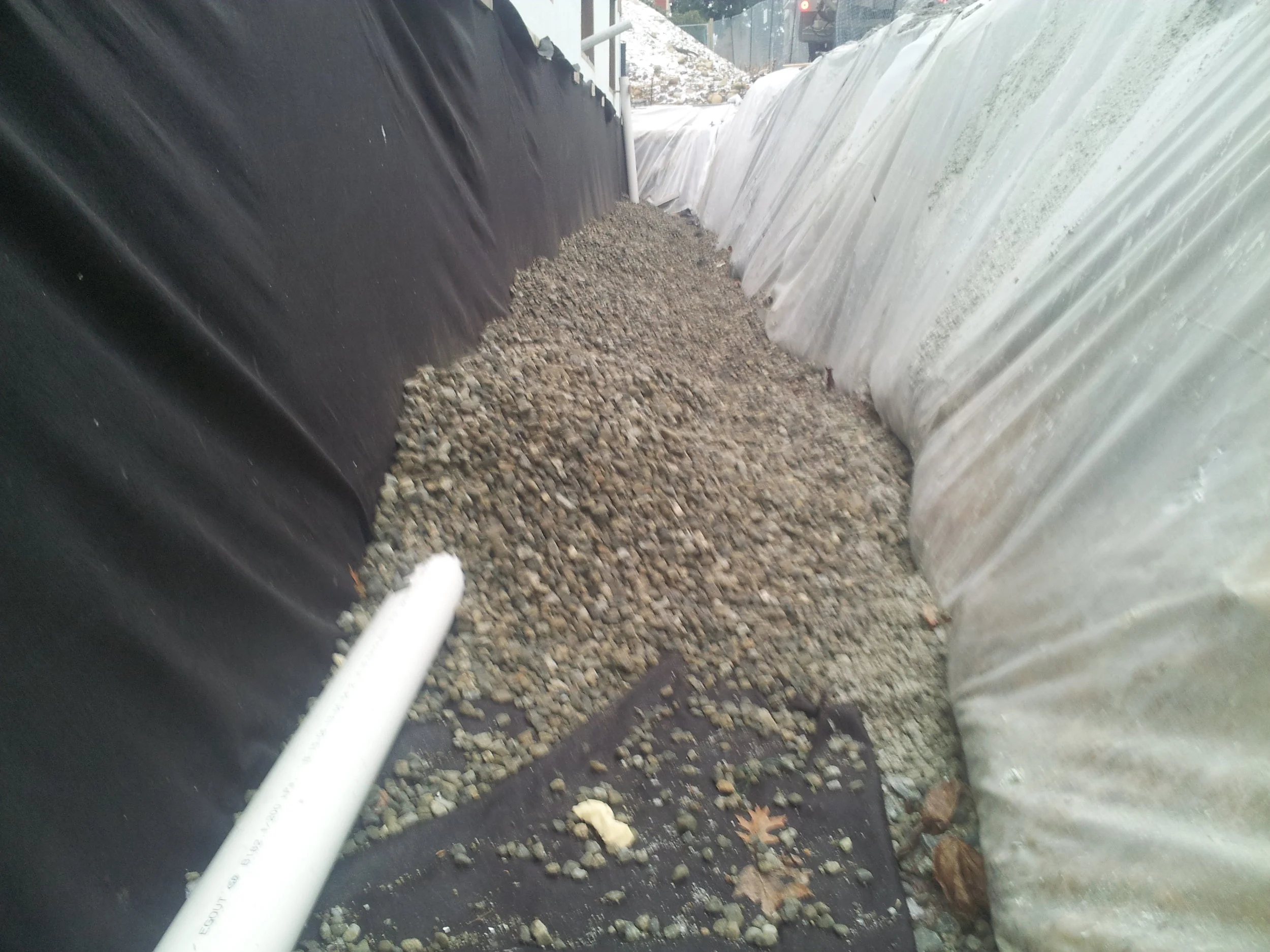 Perimeter drain tile and filter fabric cover that is draped over the rock before backfill. This prevents sediments from potentially clogging the perforated pipe