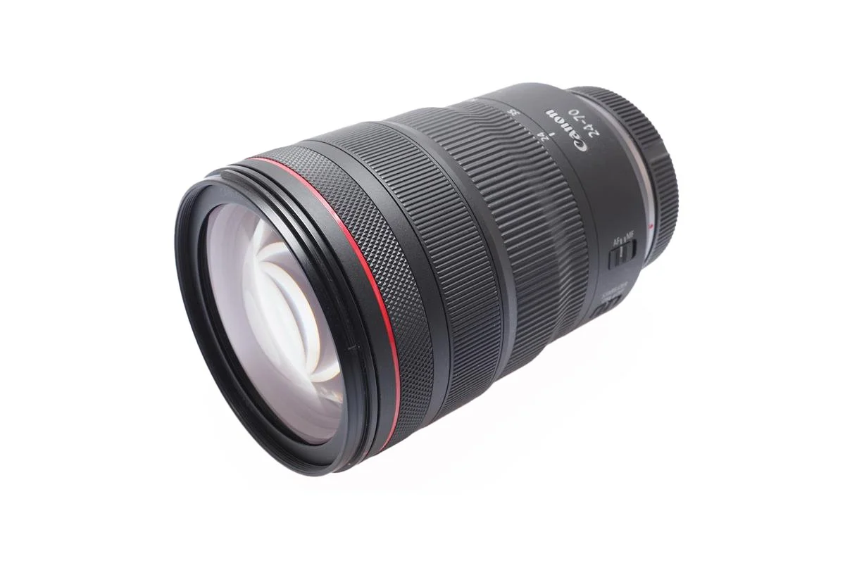 A professional telephoto camera lens with a black body and red ring, branded as Canon 24-70mm, 2.8L.