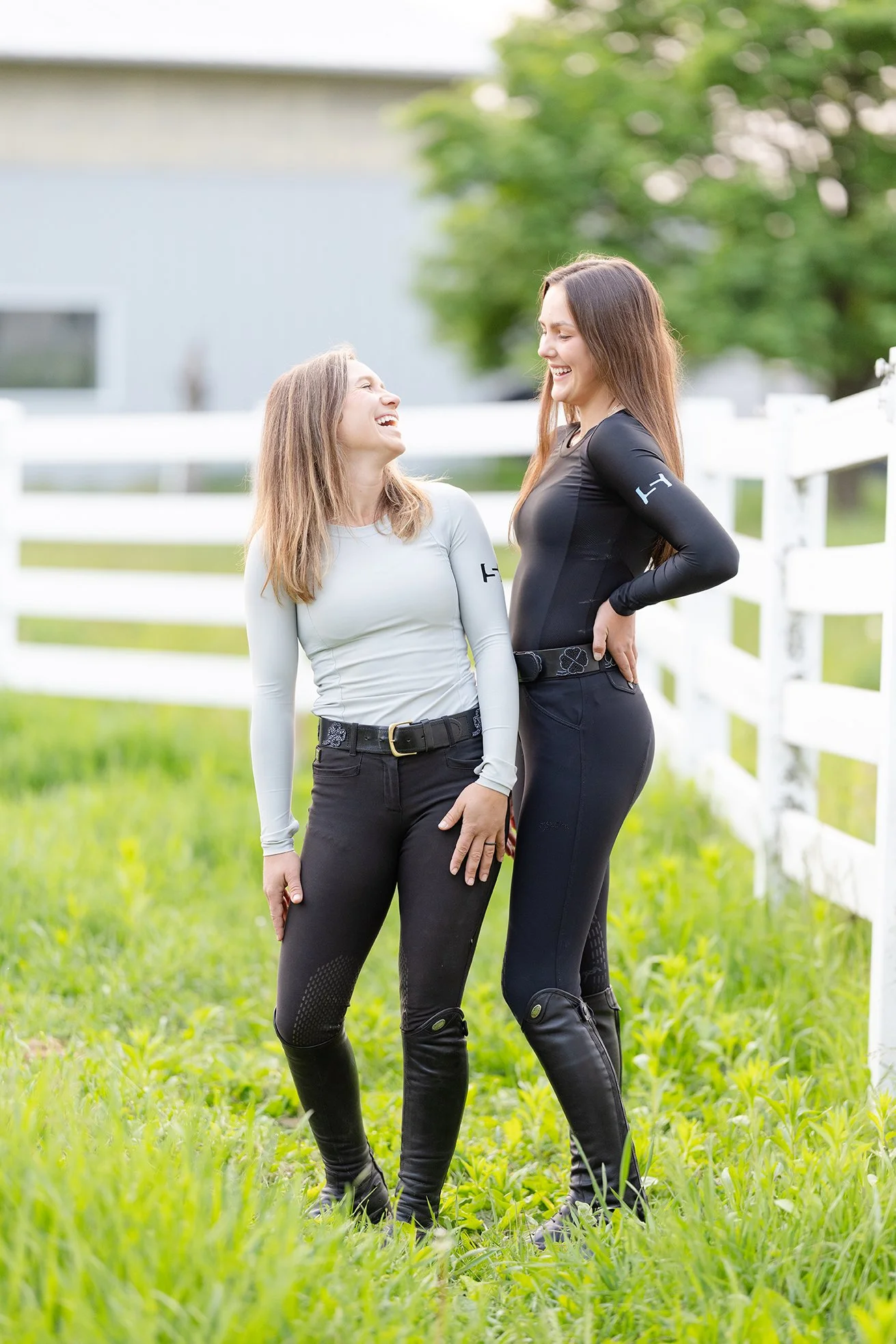 Two female equestrians laughing together in STS riding apparel at Northstar Equestrian.