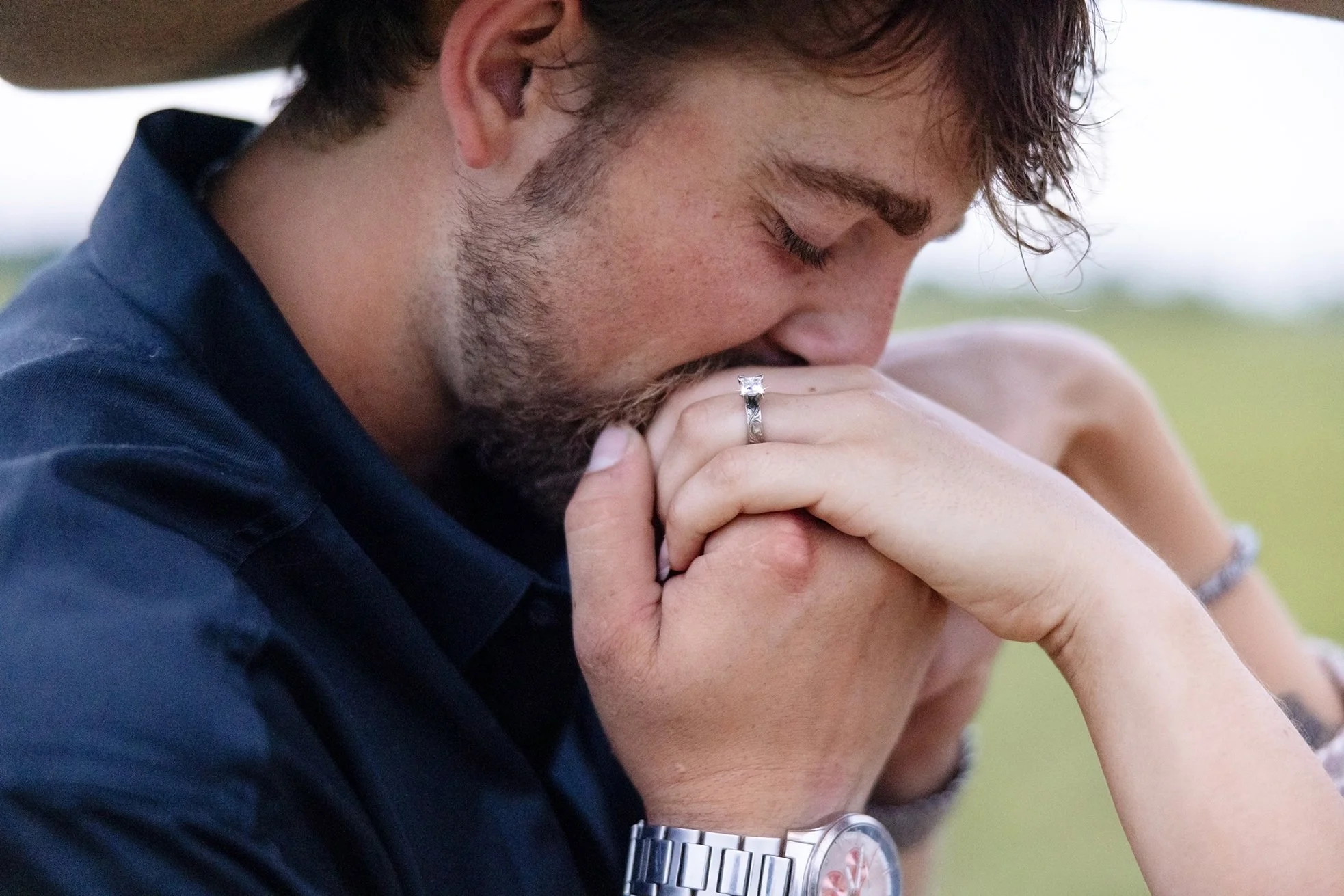 A close-up of Isaac kissing Amber’s hand showcases her engagement ring during their intimate western engagement session at Advanced Horsemanship in Poynette, Wisconsin.
