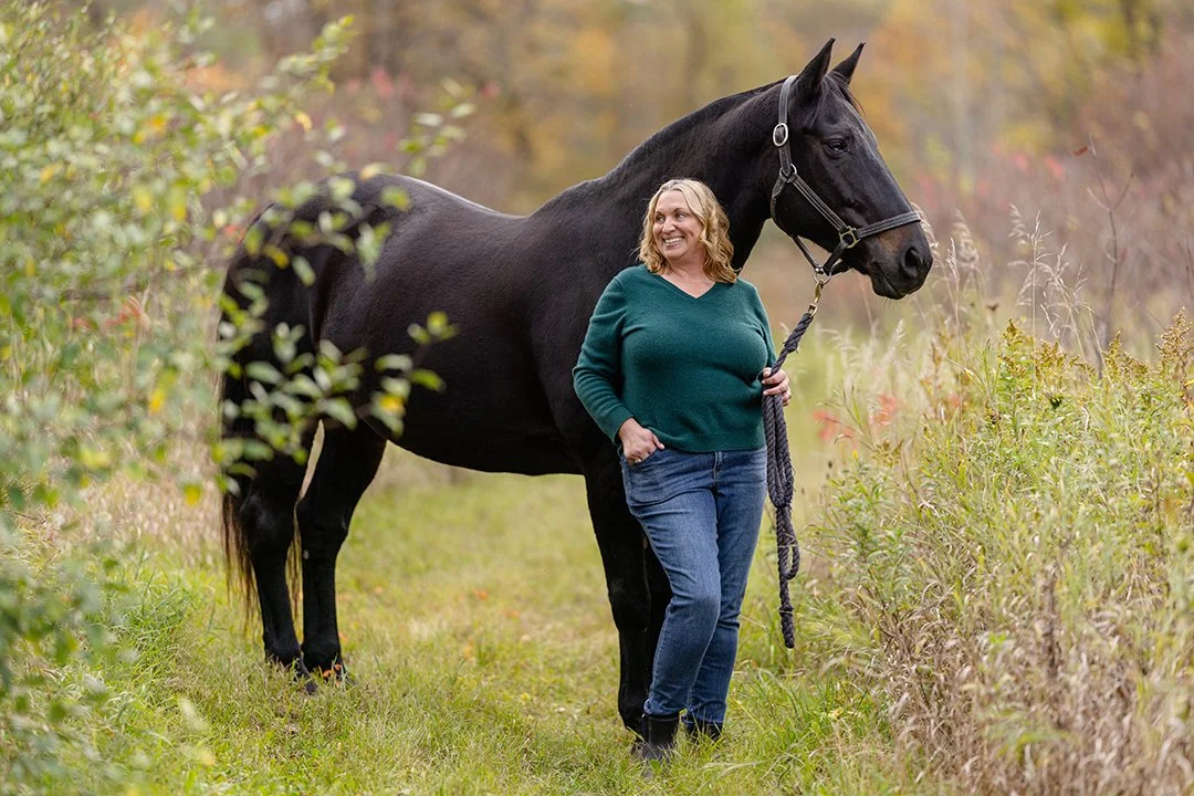 Julie and her horse stand in a grassy trail during a candid horse and rider portrait session near Plymouth, Wisconsin.