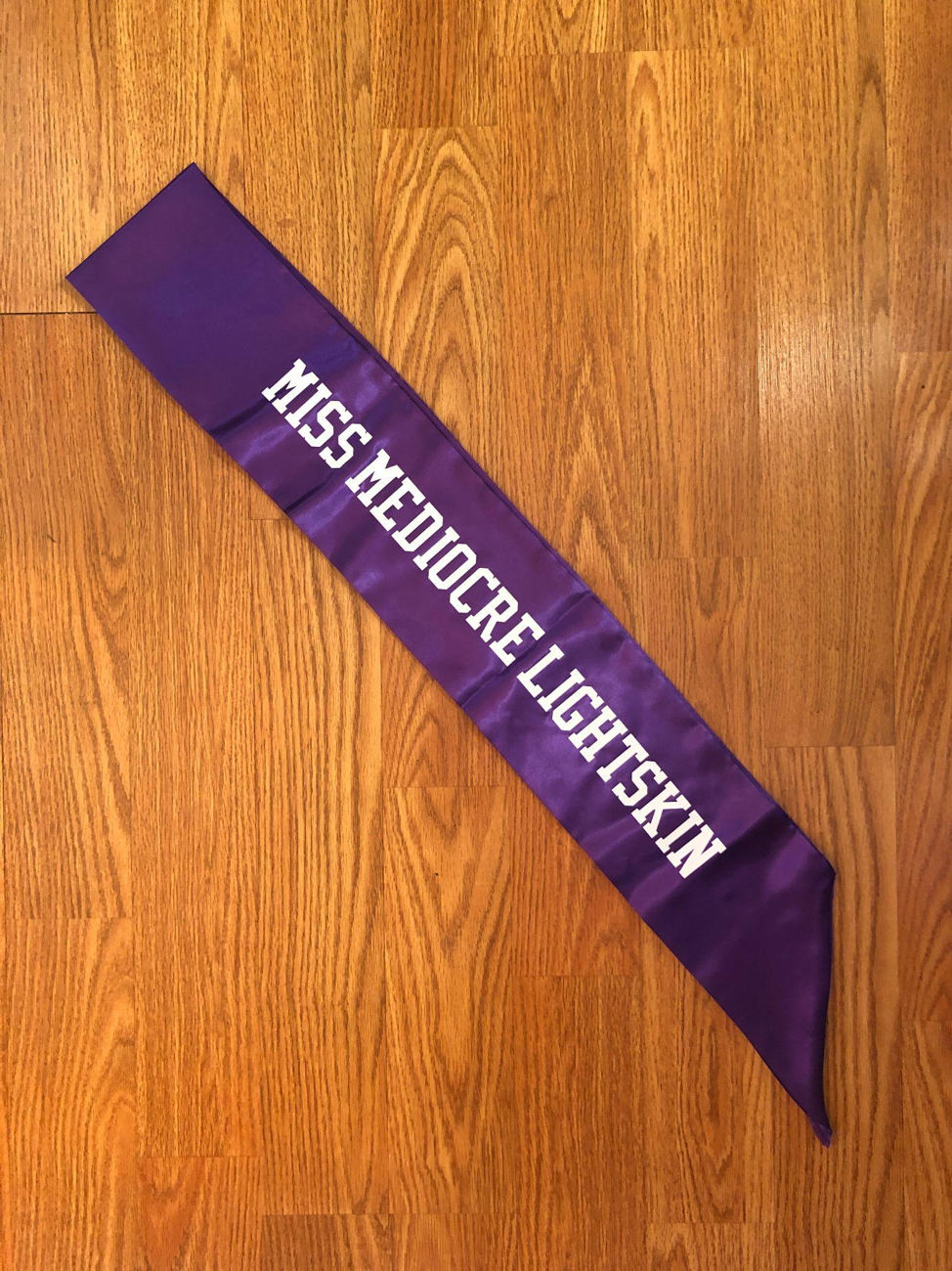  Pageant sash with text  This piece, part of an ongoing series of pageant sashes, explores troupes within the Black community that align with lighter skinned and multi-racial identities. It also explores my relationship to my own complex background, 