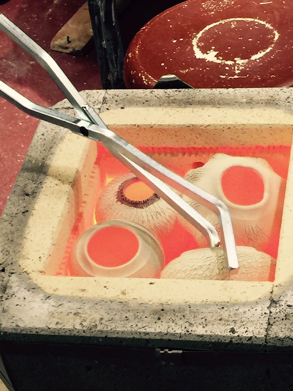   Image: Pulling pieces from hot kiln, ready to dunk in obvara slurry – as with raku – to complete finish.  