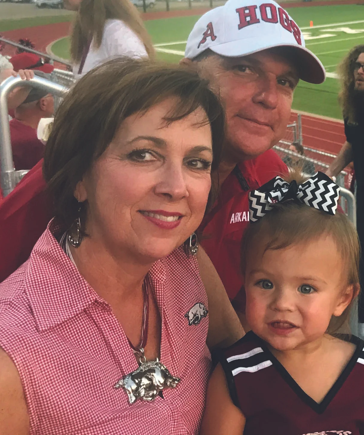 Shelby and Allen with their granddaughter, Sutton, during an Arkansas High football game.