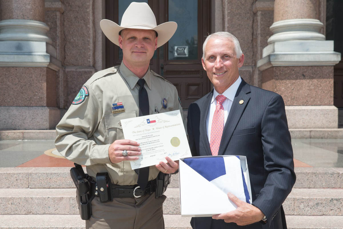 Rep. VanDeaver presents Joseph Sellers with a Texas flag flown over the Capitol in honor of Joseph becoming a Texas Game Warden in August 2017.