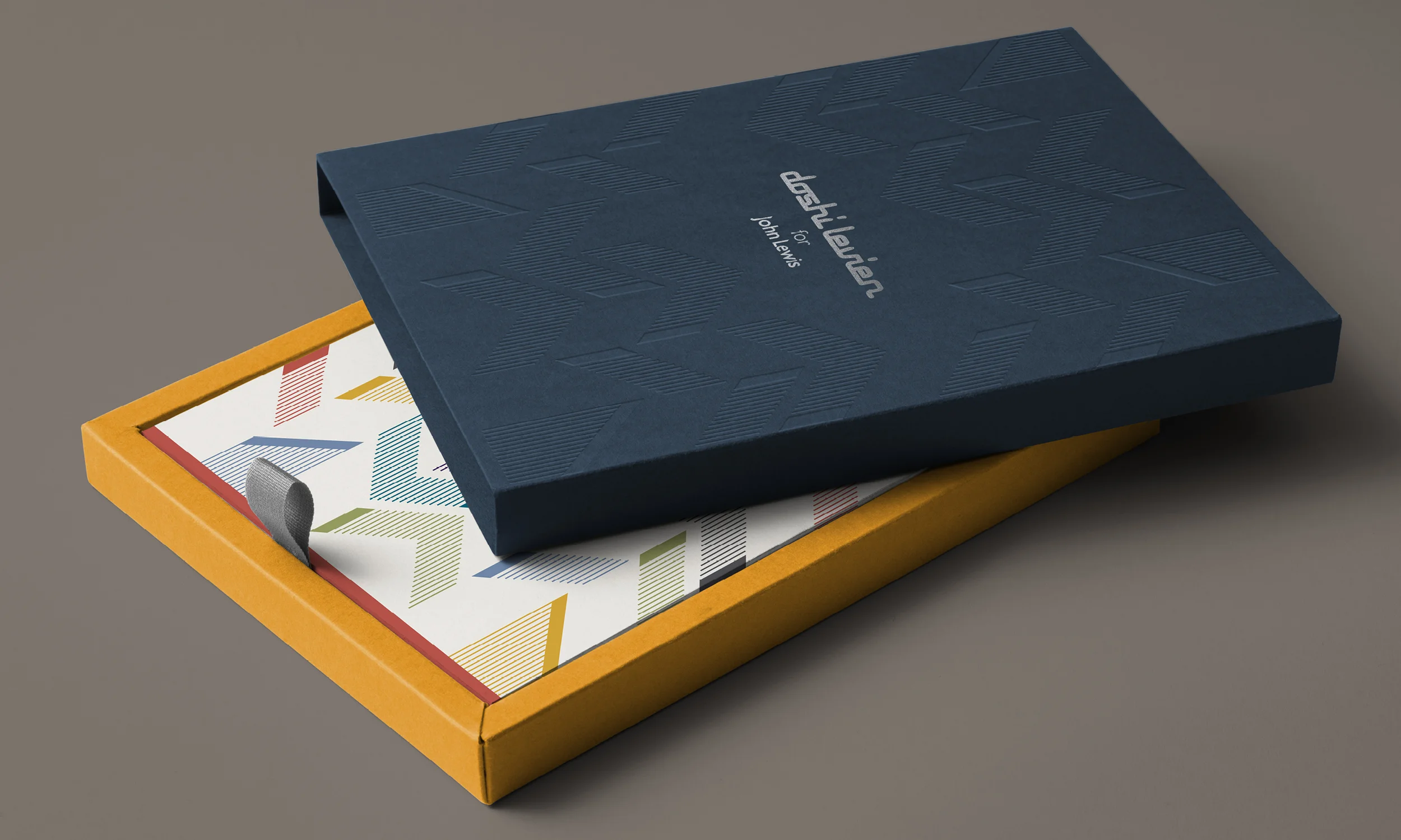 A pattern taken from Doshi Leviens exclusive range was blind debossed (creating an impression) onto the outer sleeve of a presentation box to echo the collections concept, basing it around light. The logo was foil-blocked using a metallic silver.