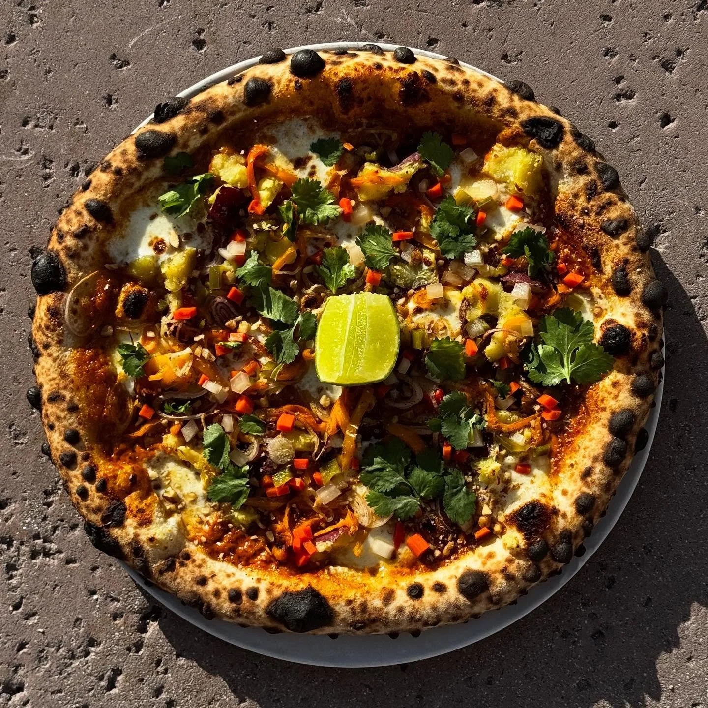 Sweet potato massaman pizza on for lunch today! Mozz, @burlapandbarrel spiced curry, sweet potatoes, lunchbox peppers, pickled daikon, carrots &amp; jalape&ntilde;o. Herbs &amp; lime to finish.