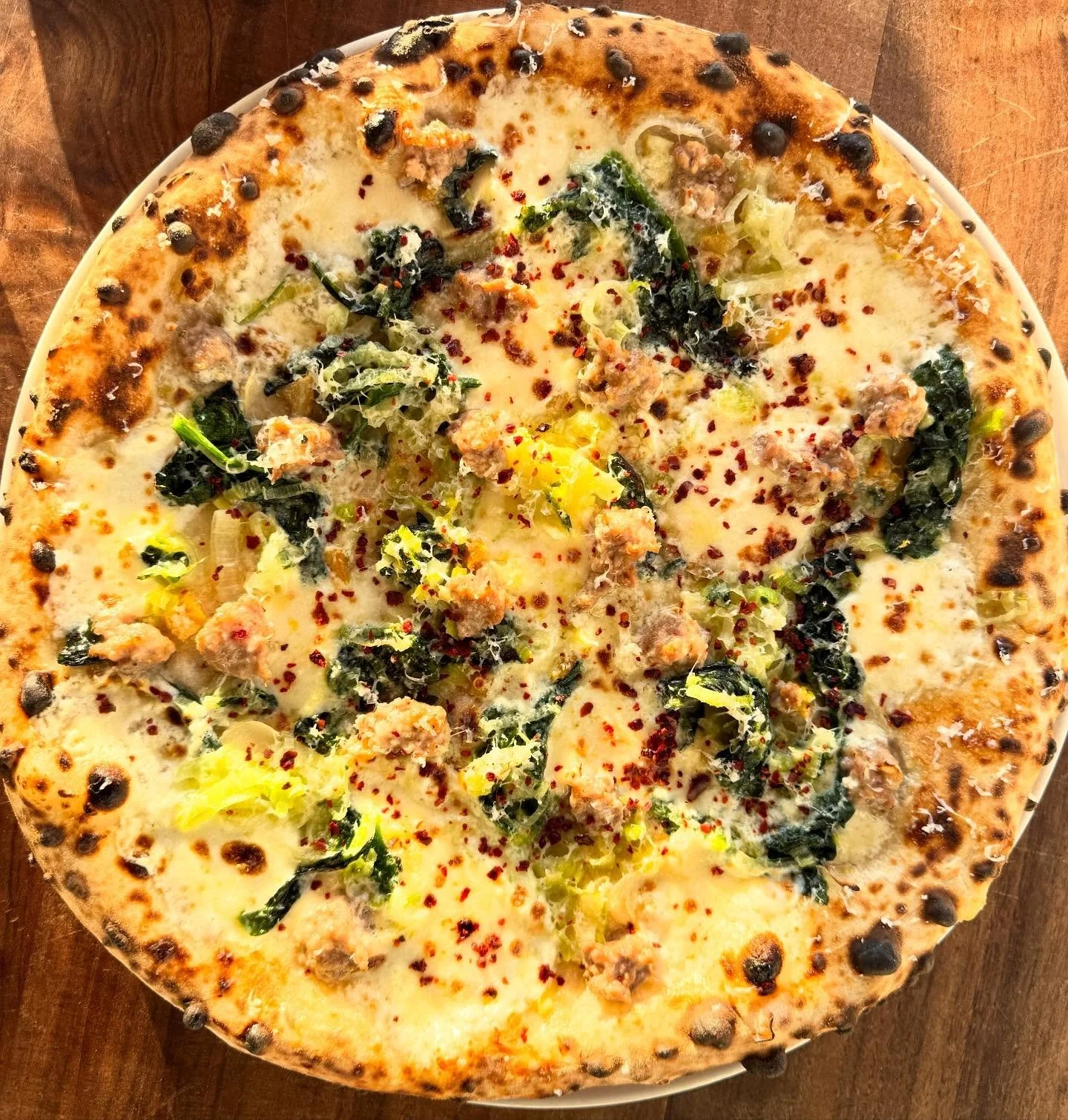 With peppers heading out of season, we&rsquo;ve got a new sausage pizza on the menu today. @roots_organic_farm spinach and leeks saut&eacute;ed with lots of @strausmilk butter. Mozz and house ricotta as the base plus preserved lemon, garlic oil and a