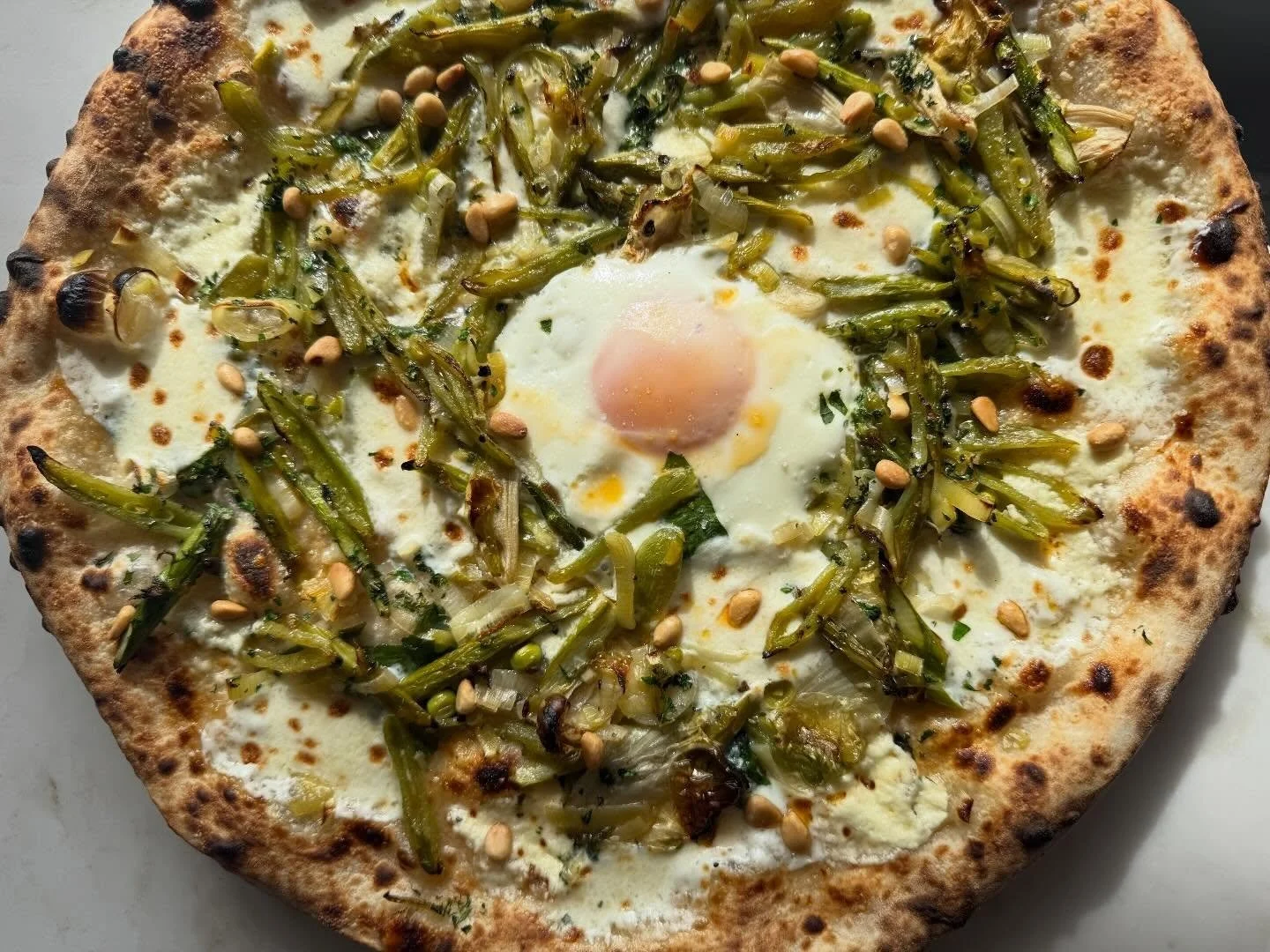 This year we went in a slightly different direction for our usual sugar snap pea pizza. @oscar_desantiago_ went all in on spring veggies with a medley of braised @roots_organic_farm sugar snaps, @mendozafamilyfarms asparagus, @sbcfma escarole and lee