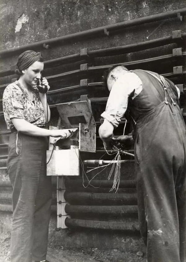 A signals-woman linesman at work on the Underground during the Second World War, apparently testing a trackside telephone.

Photographer Fox Photos, London Transport Museum.