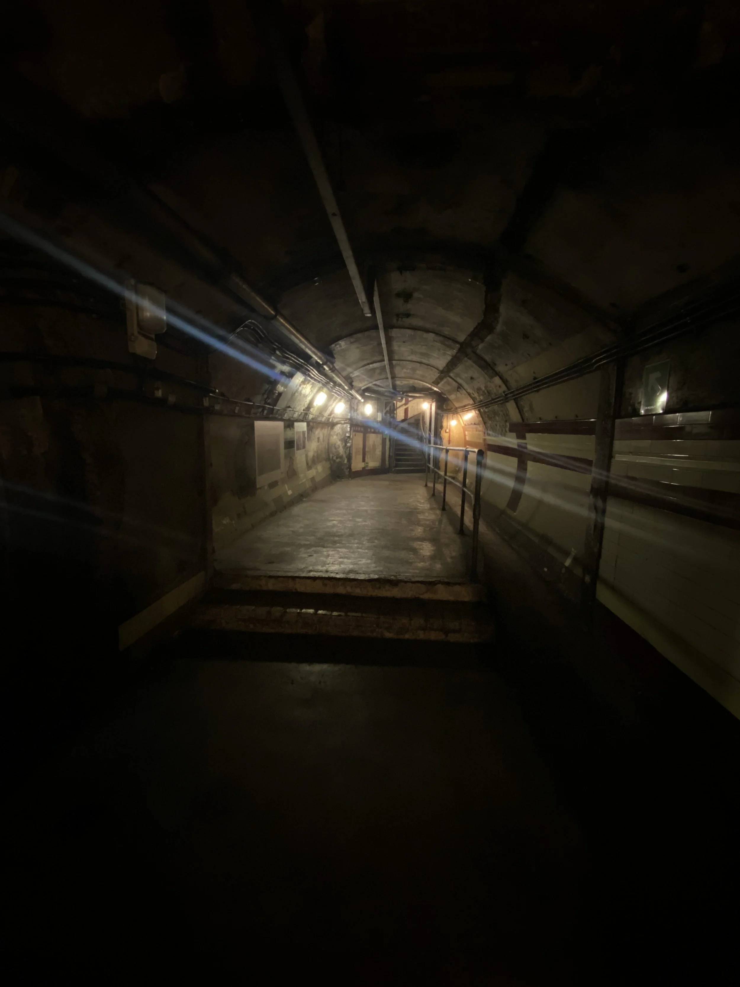 Portion of passageway tunnel modified to create the typists' room at Down Street. Because passageways lead downward toward the platforms of the station, the grade made the space unsuitable for seated work involving things that roll downward (i.e., pe