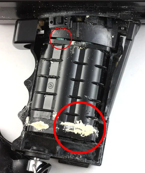 The battery compartment of a broken Super 8 camera. Two obvious signs of corrosion are circled in red.