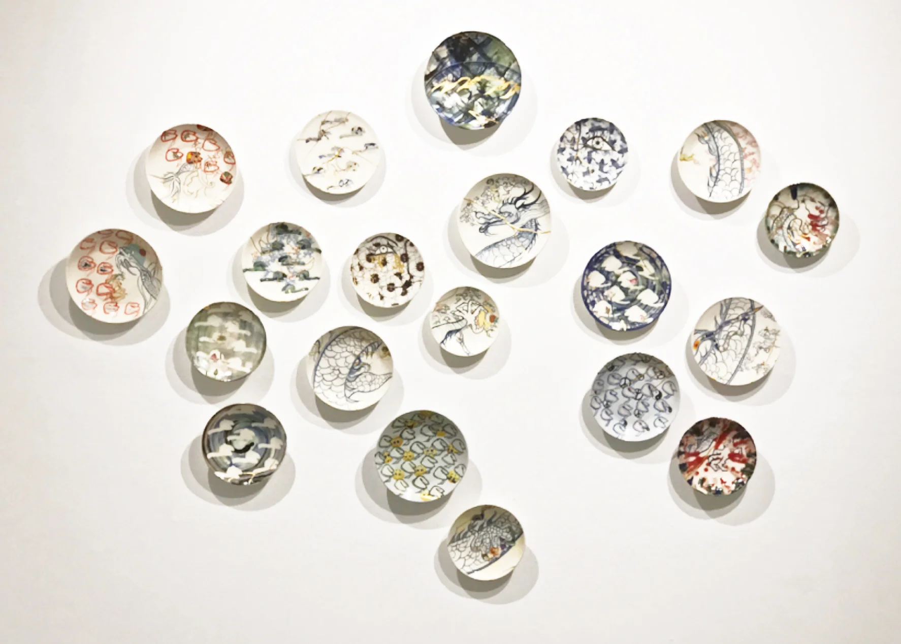 Transformational Plates, 2016, porcelain, gold leaf, lacquer, hand-painted decoration, China paint Variable dimension