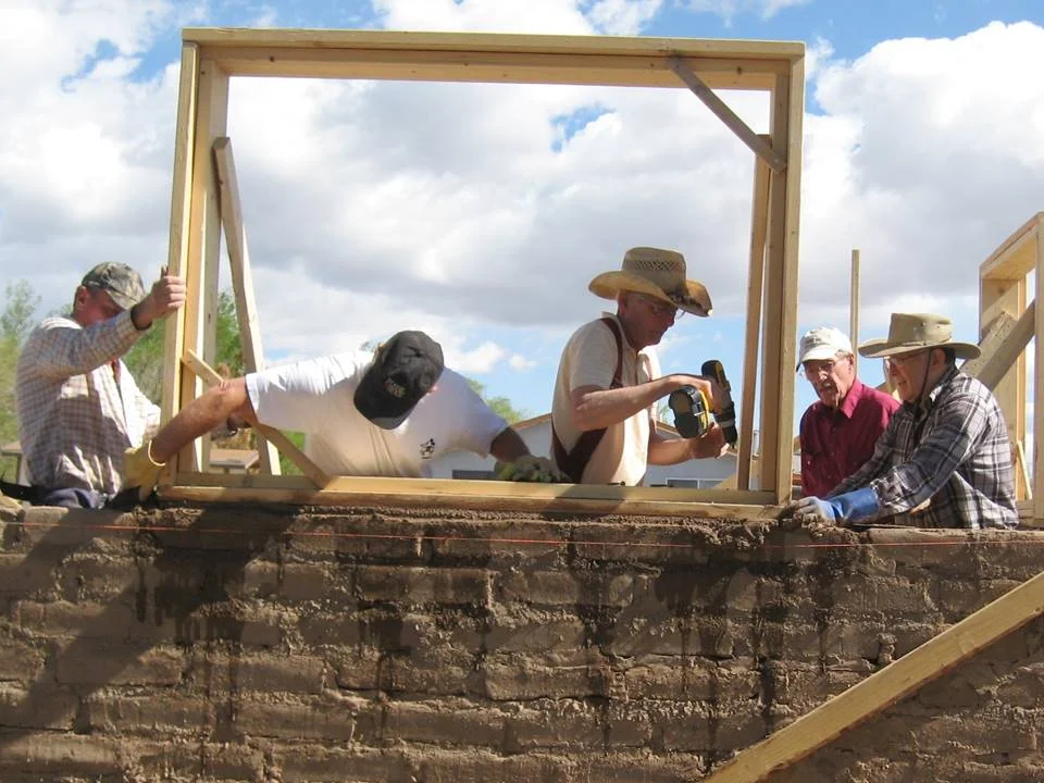 Building Houses, Building Hope: Volunteers working hard on an adobe house constructed under the auspices of the San Luis Valley Habitat for Humanity.