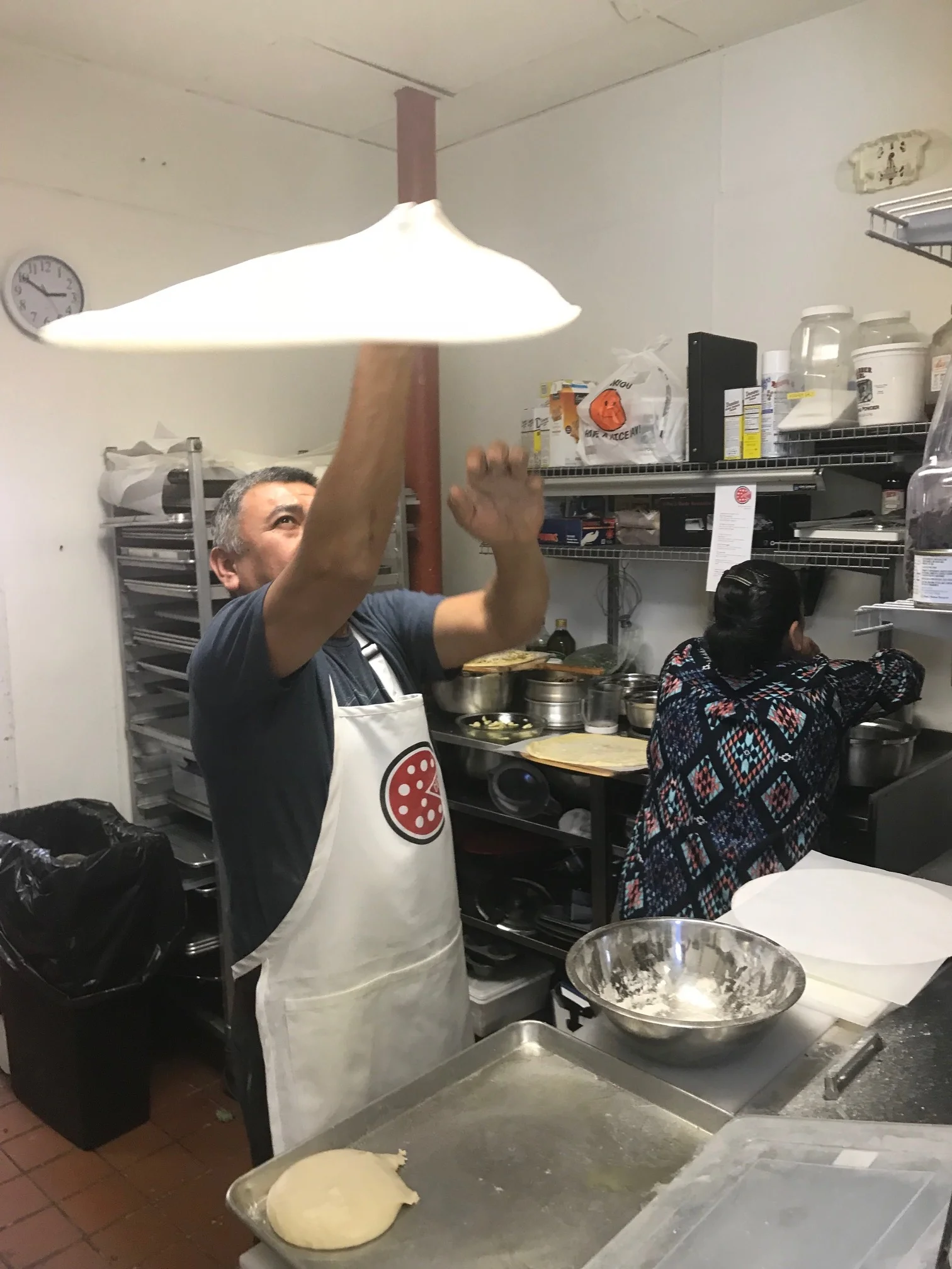 One of the crew shows how we throw the dough!