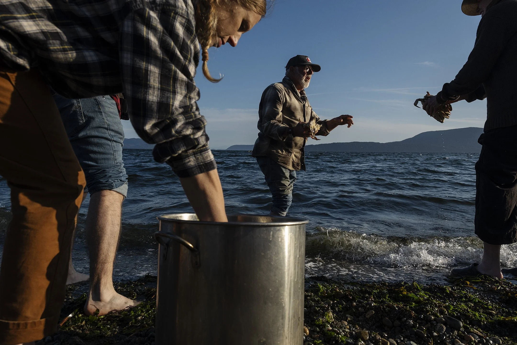 At a celebratory beach cookout, crew members clean freshly caught crab for the evenings dinner.