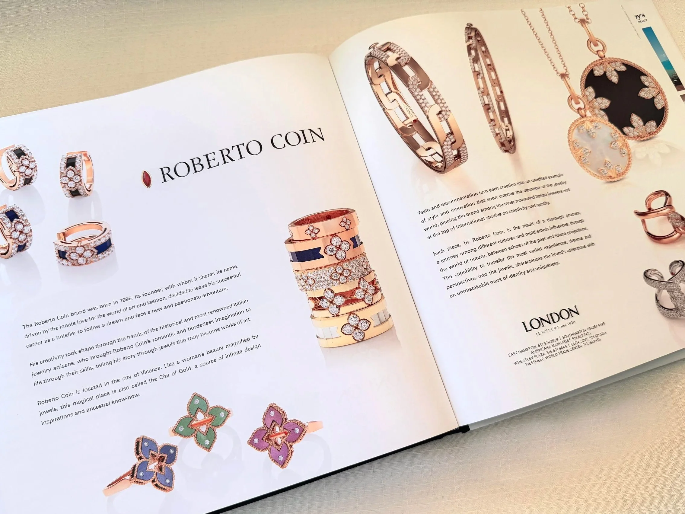 Open jewelry catalog showcasing various jewelry pieces including rings, bracelets, and a necklace, with the brand name Roberto Coin.