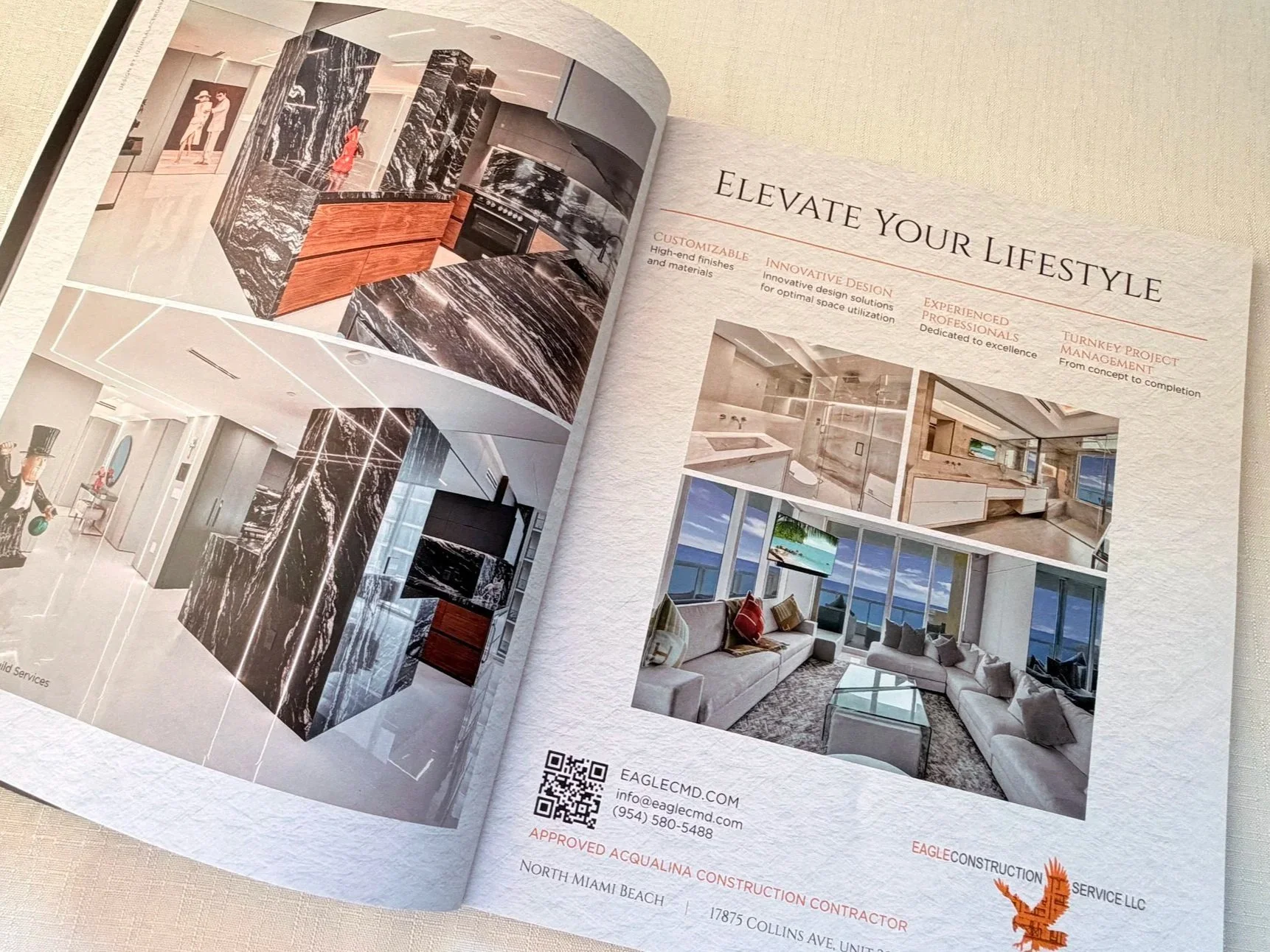 Open brochure showing interior design and renovation project images including a kitchen with marble surfaces, a living room with large windows and ocean view, and promotional text for Eagle Construction Services.