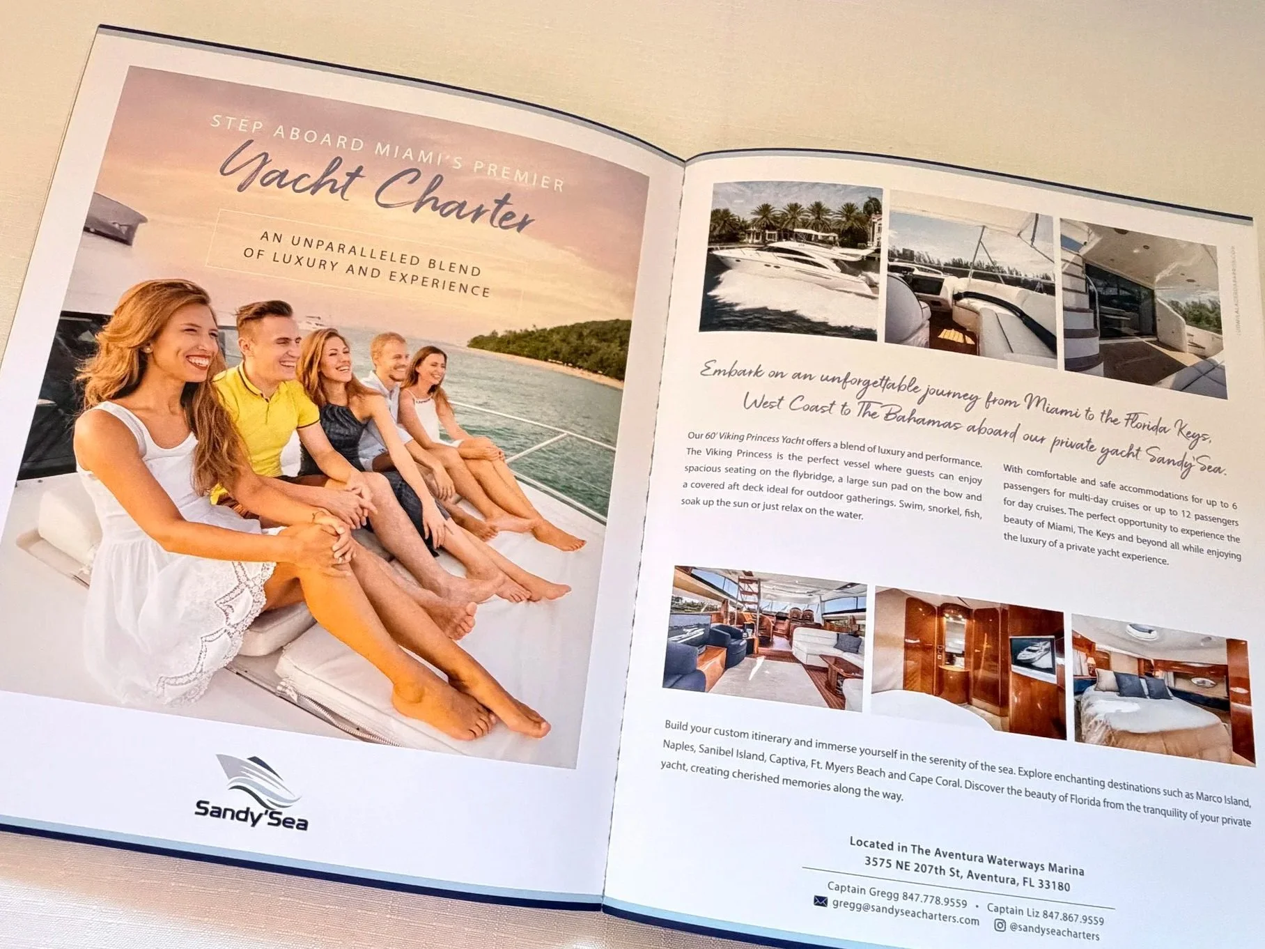 Open brochure featuring a large image of six people sitting on a yacht deck, smiling and enjoying the sunset. The brochure promotes yacht charters with information about a luxury yacht service, including pictures of the yacht's interior and exterior,