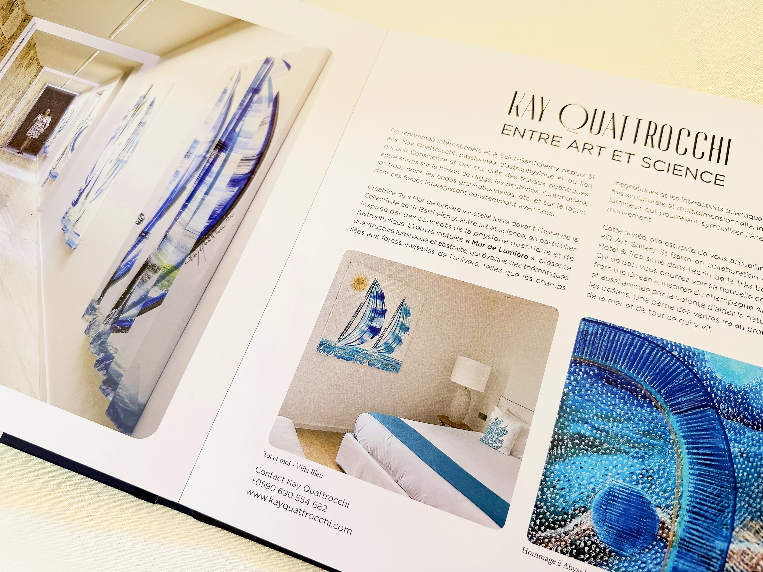 A printed promotional booklet open to pages featuring artwork of colorful glass sculptures and a photo of an interior with a blue and white couch, along with descriptive text in French about artist Kay Quattrochi and her work.