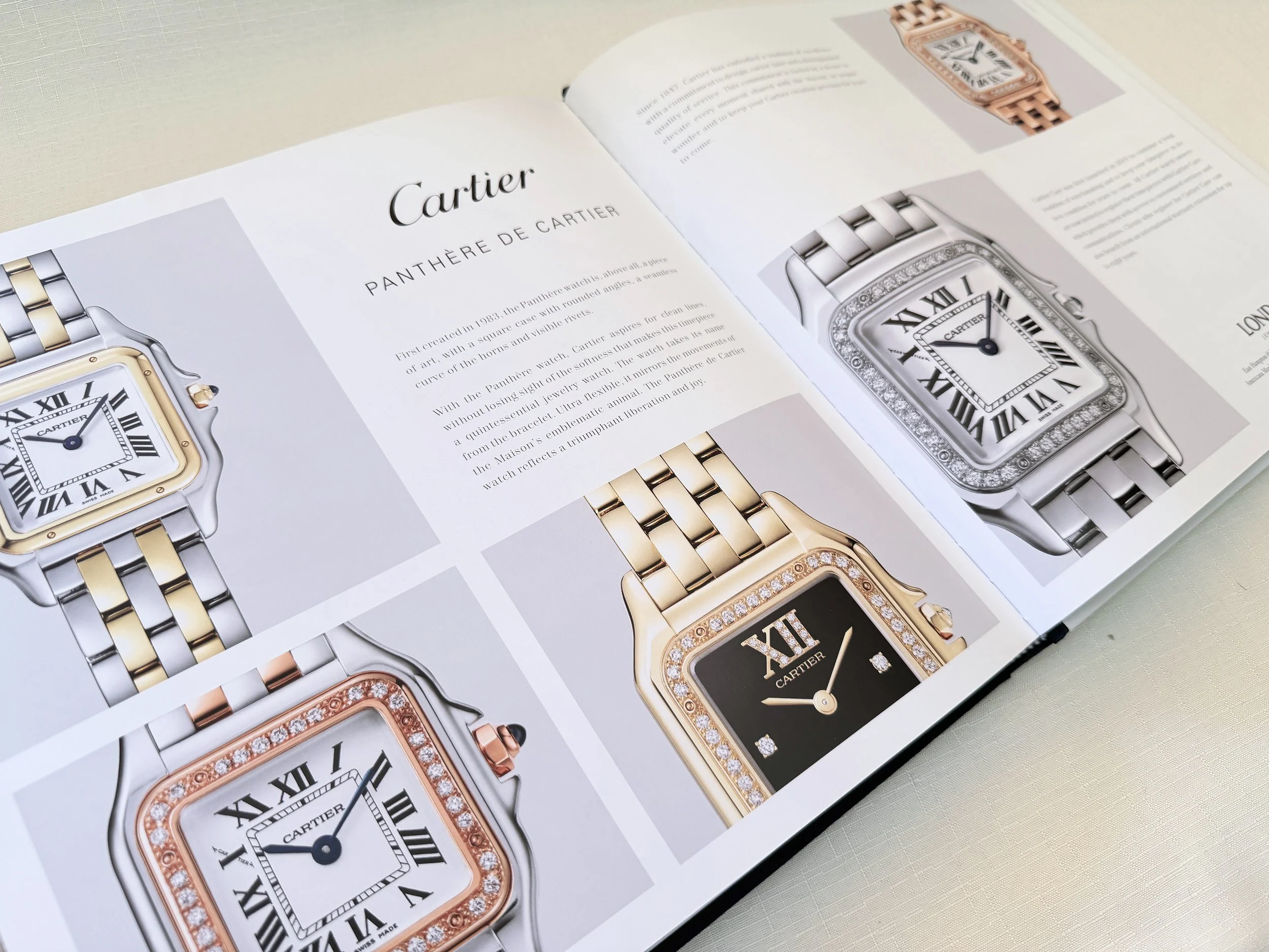 Open book showcasing Cartier luxury watches with detailed descriptions and images of various models, including one with a diamond-studded bezel.