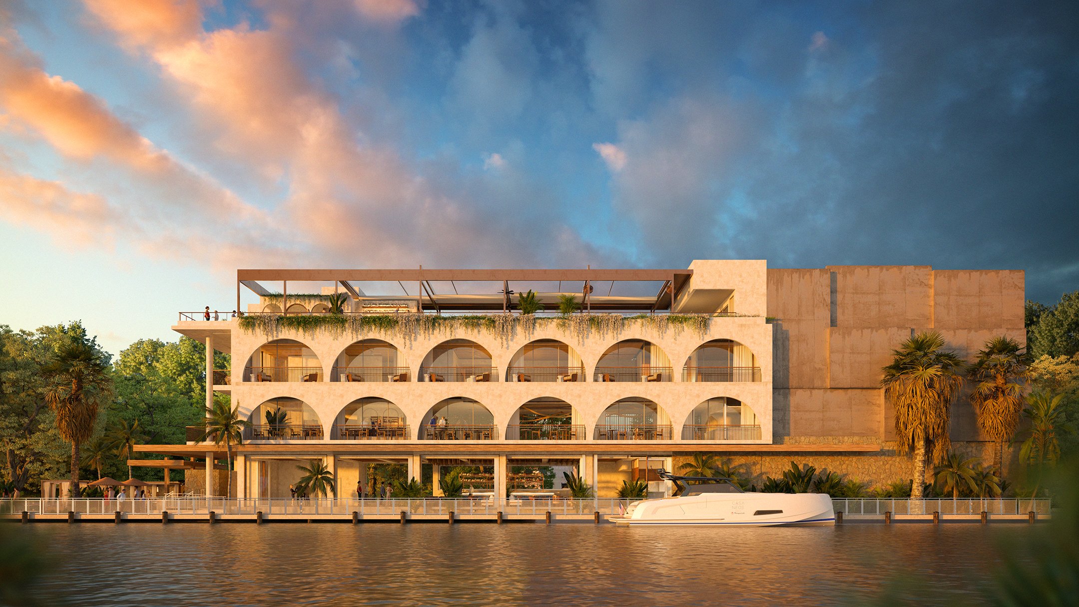 Casa Neos — a Modern multi-story building with arched balconies overlooking a body of water, surrounded by trees and palm trees, with a partly cloudy sky at sunset.