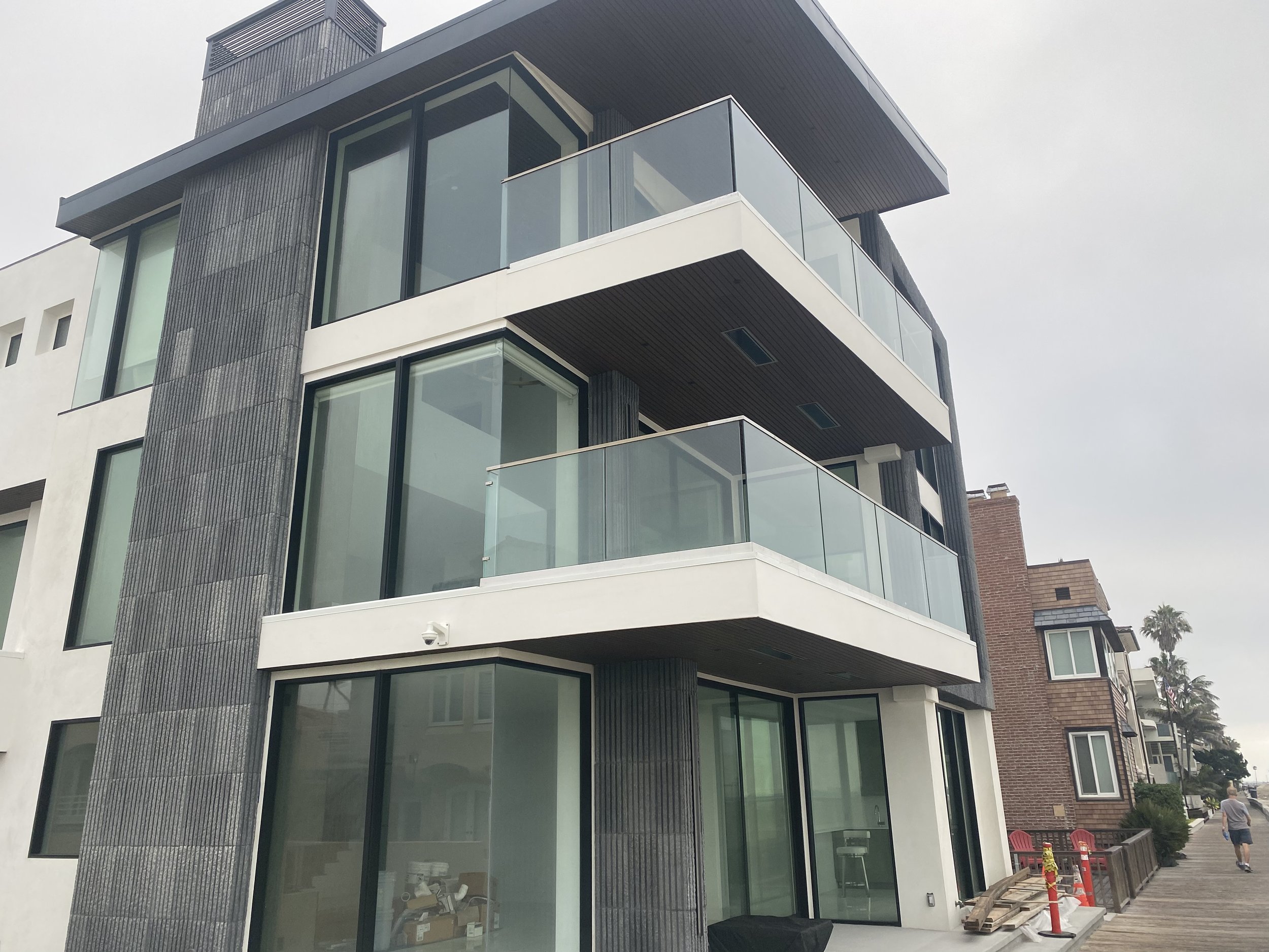Full-height stone chimney and glass-rail balconies on Long Beach Peninsula home