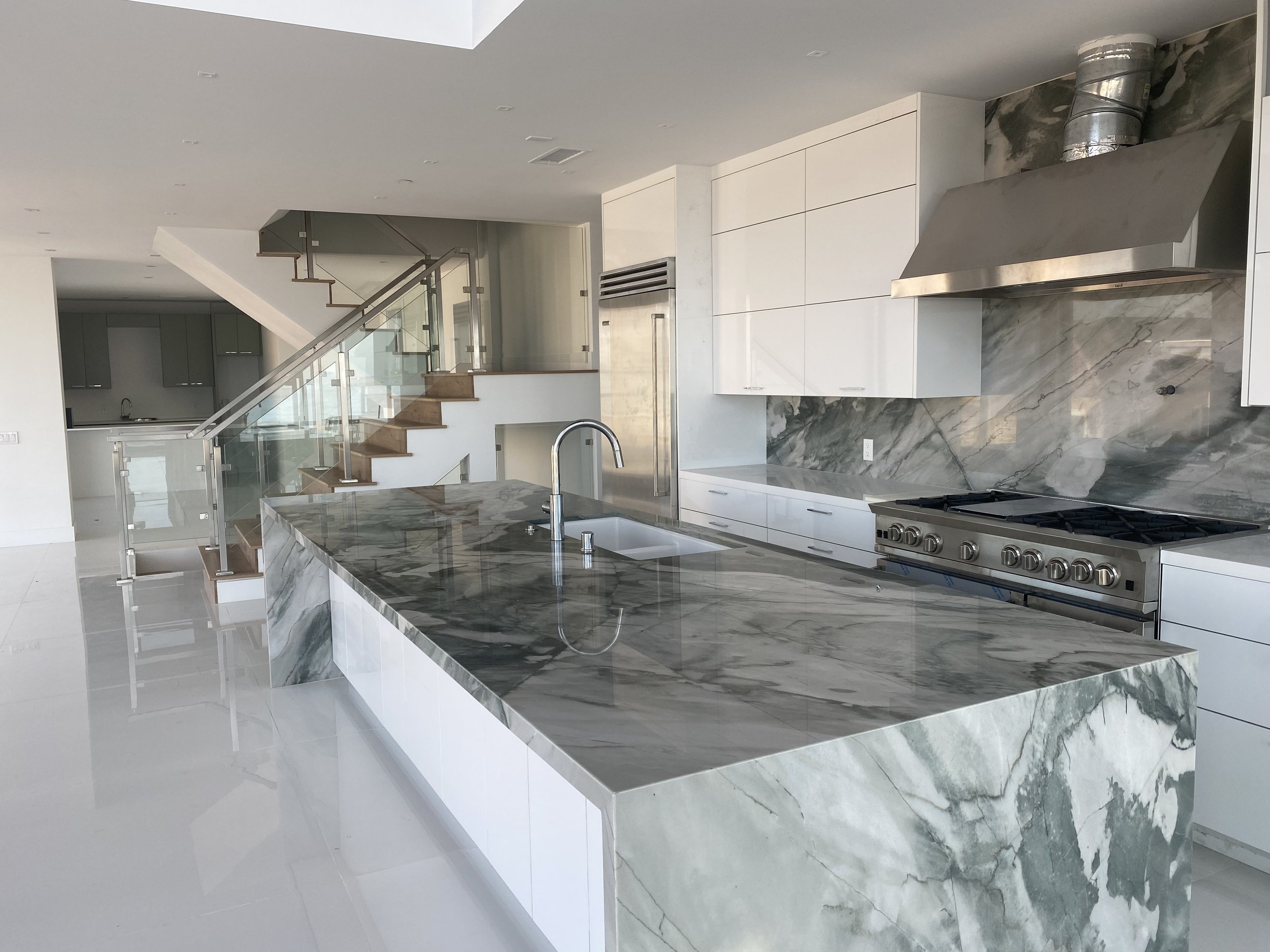 Kitchen with stone slab island in new Long Beach beach home