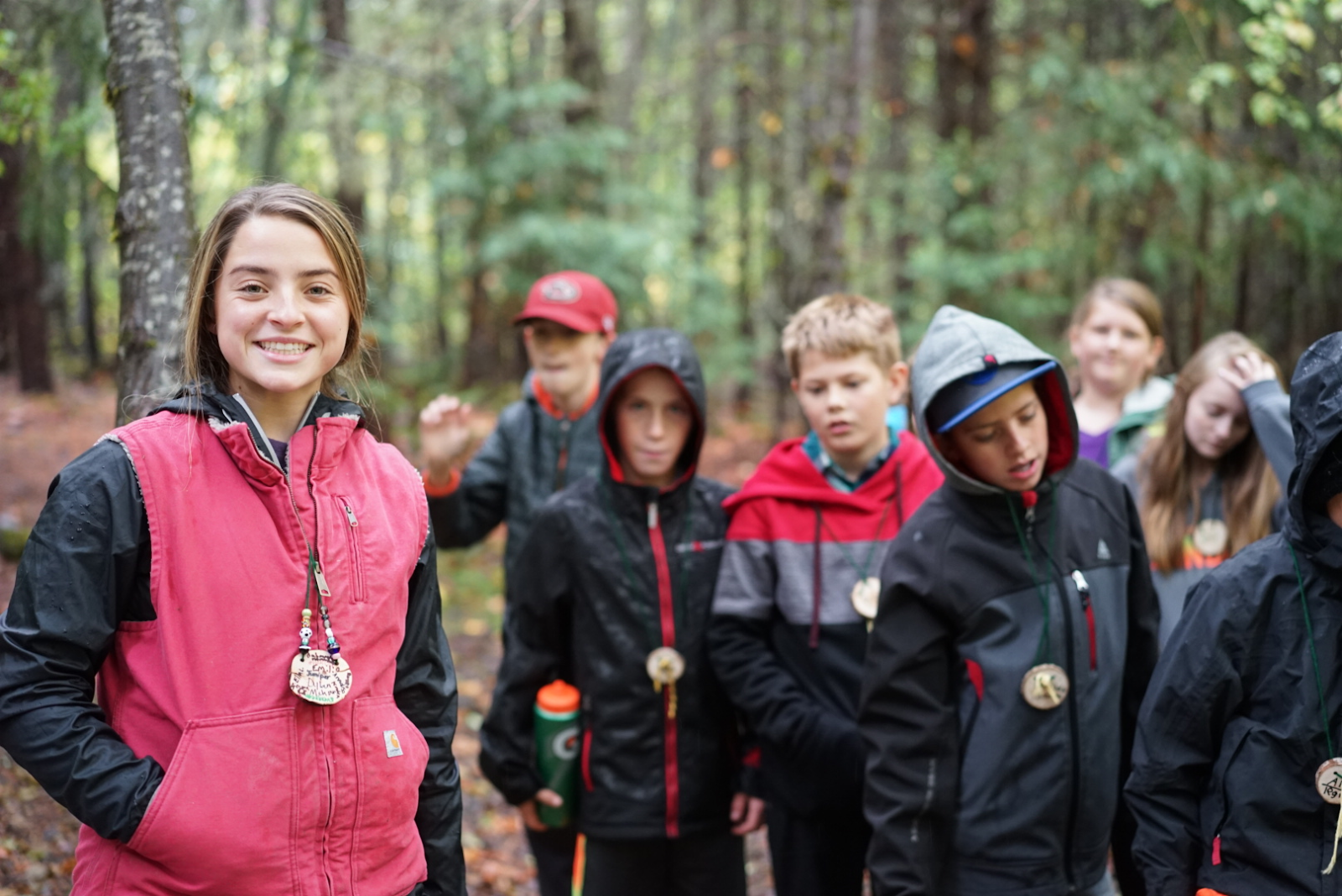 Smiling high school student leader with a group of middle school students.