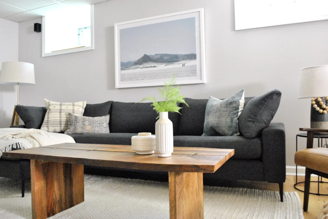A large sleek sofa with live edge table and leather chair make for the perfect family basement space.