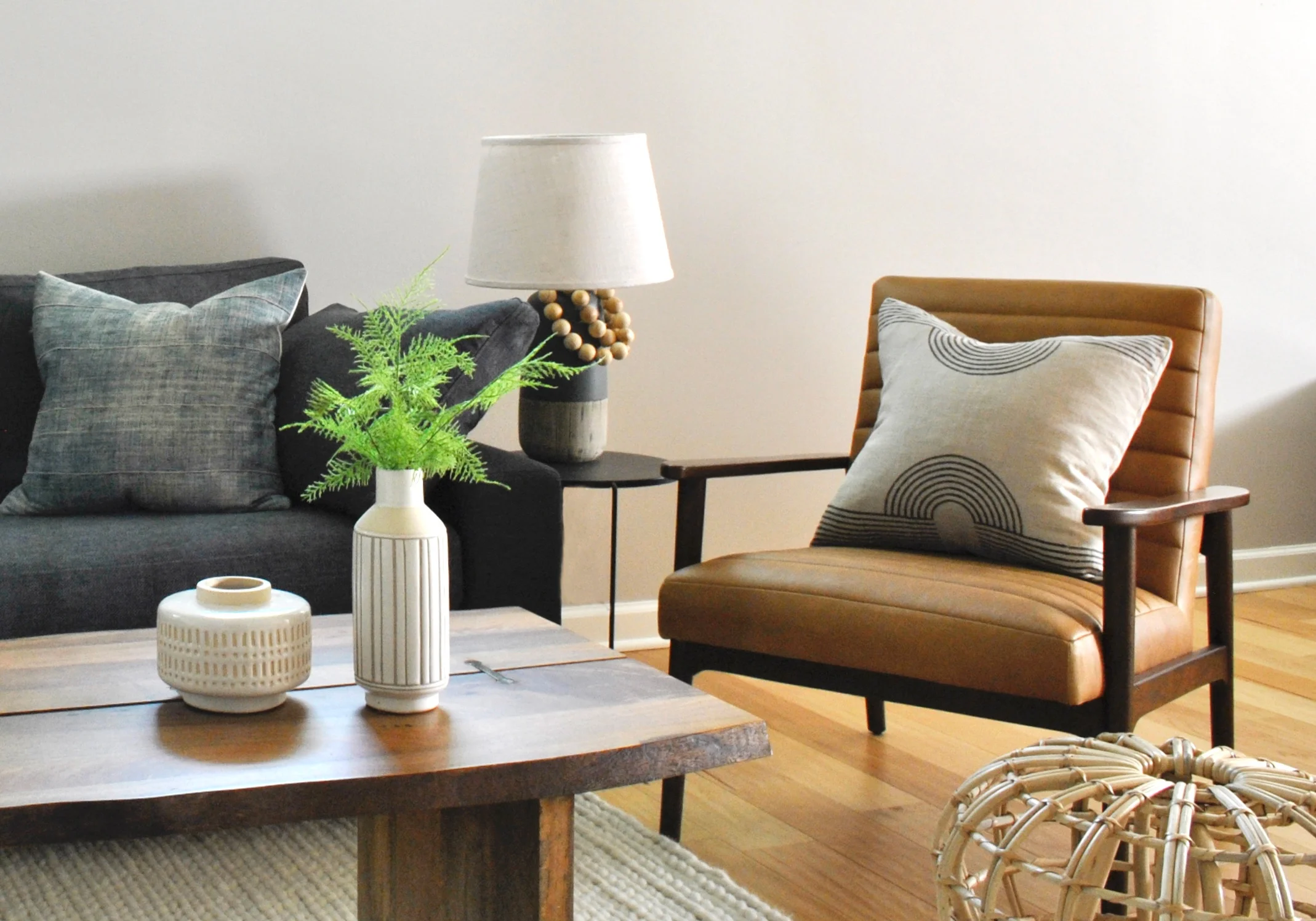 Light and bright basement remodel with light wood floors and mid-century style leather chair.