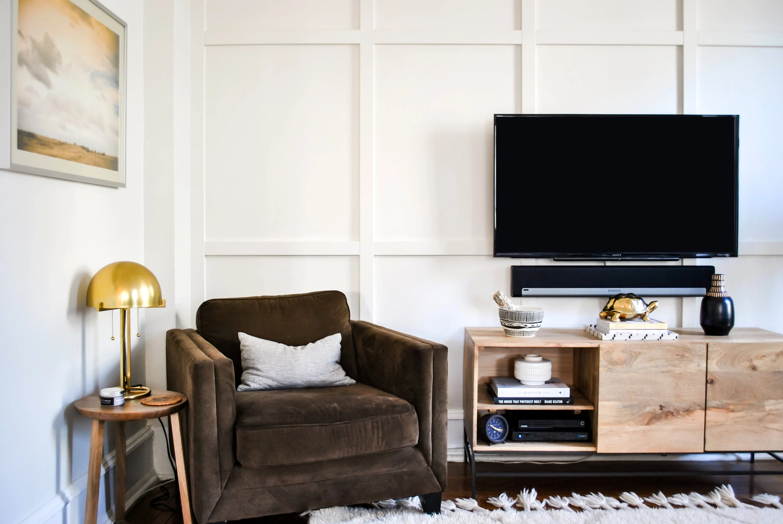 Comfortable family living room with focal wall painted in Benjamin Moore Classic Gray, brass accents, vintage striped pillow and Moroccan rug | Sharp + Grey Interiors.