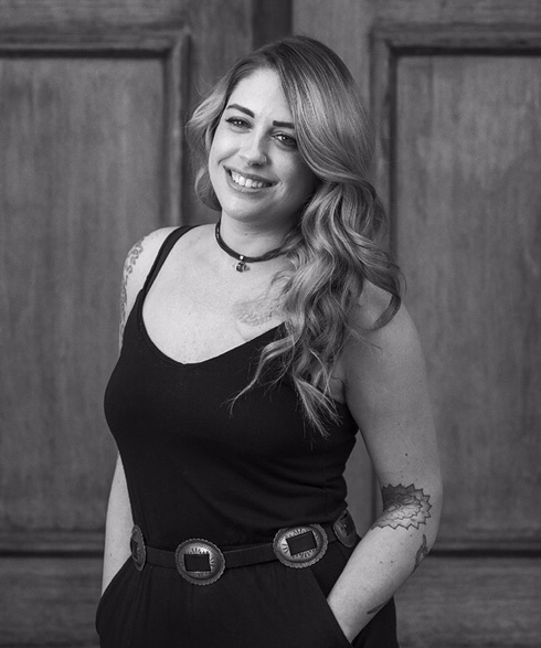 Danielle Kozloff wasn’t always a hair nerd. Danielle attended the University of Central Florida for journalism and after graduation ended up working an office job which she quickly found wasn’t for her. Her love of makeup led Danielle to cosmetology school where she discovered a deep passion for hair. Danielle graduated from the Aveda Institute in St. Petersburg, Florida in 2009. After licensure, Danielle attended a two-week intensive apprenticeship before working behind the chair. In 2012, Danielle moved to New York City where she began working as a hairstylist in Manhattan. While working behind the chair at a salon in Soho, Danielle also worked on-location for music videos. Danielle also became certified in tape-in hair extensions and found a new path as an extension specialist. Danielle moved to Denver in 2014 and has been a Denver stylist ever since. She has taken numerous advanced education classes including balayage and men’s fading, as well as assisting on fashion shows including the red ball. Danielle loves dimensional color, especially hand painting techniques such as balayage, but when asked she’ll tell you her passion for hair extensions is unparalleled. Danielle joined The Retro Room in 2017. Her favorite Kevin Murphy product is the shimmer spray. Not only does it smell amazing and adds shine to the hair (with either gold or lavender flecks), it is also a treatment that repairs hair to its natural shine. Join Danielle at the retro room and try her favorite cocktail, strawberry infused vodka press.