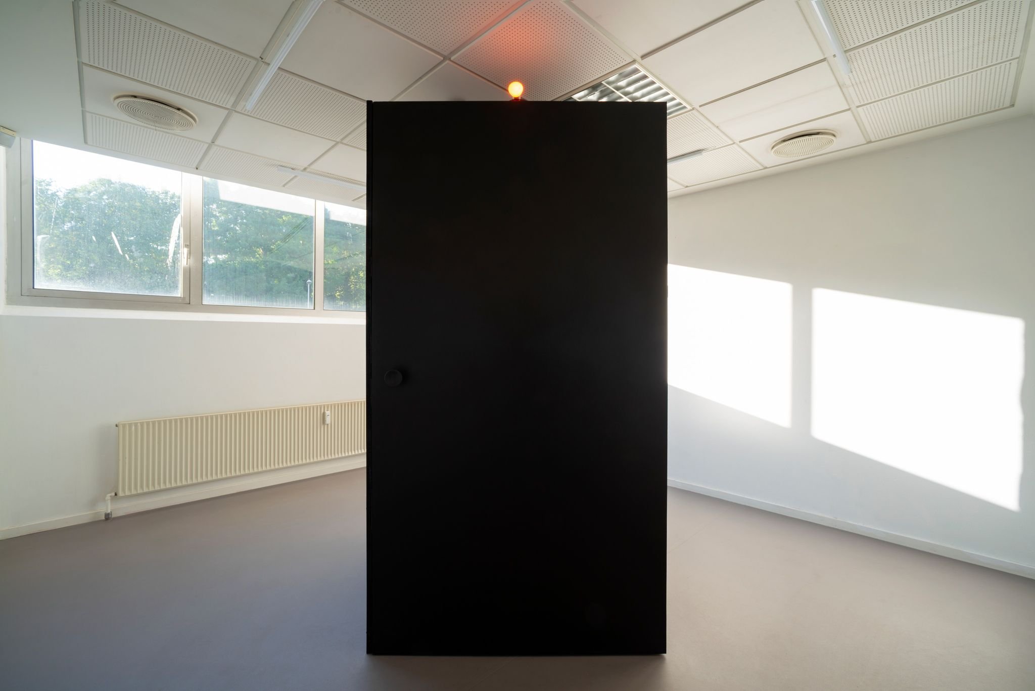 The installation exhibited at KH7smallspace august 2020. The red lamp is on, the installation is occupied / not ready to enter.