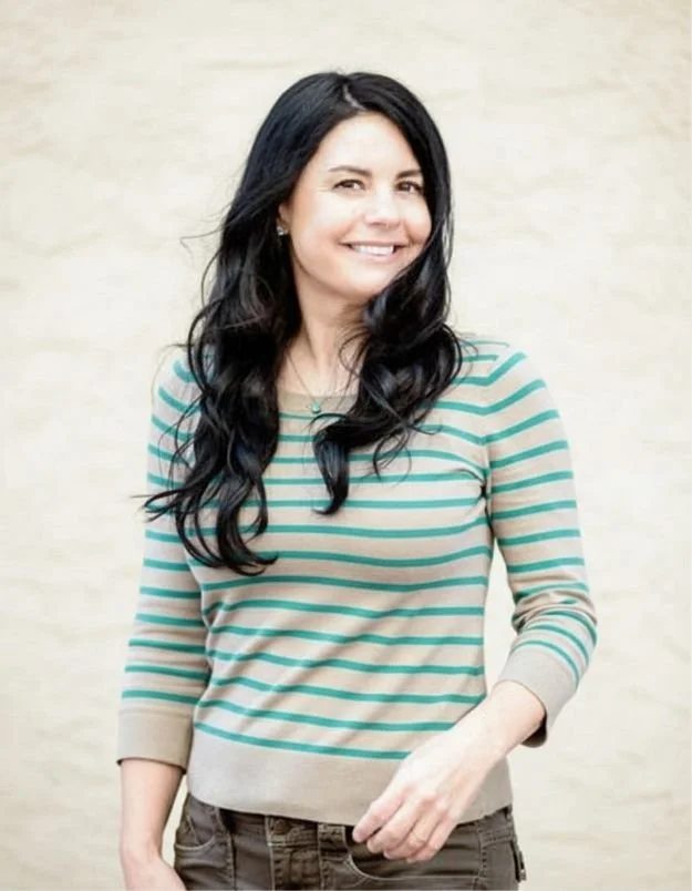 Author Lacie Waldon smiling at camera in a striped sweater
