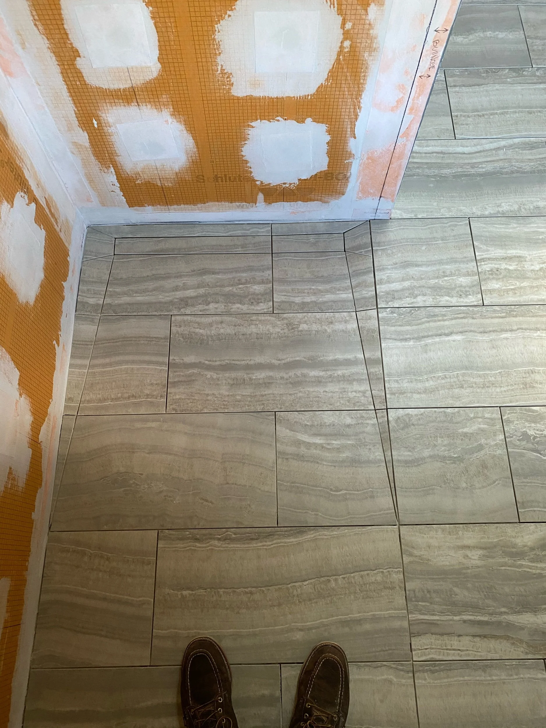 Curbless shower base with hidden tiled drain cover  