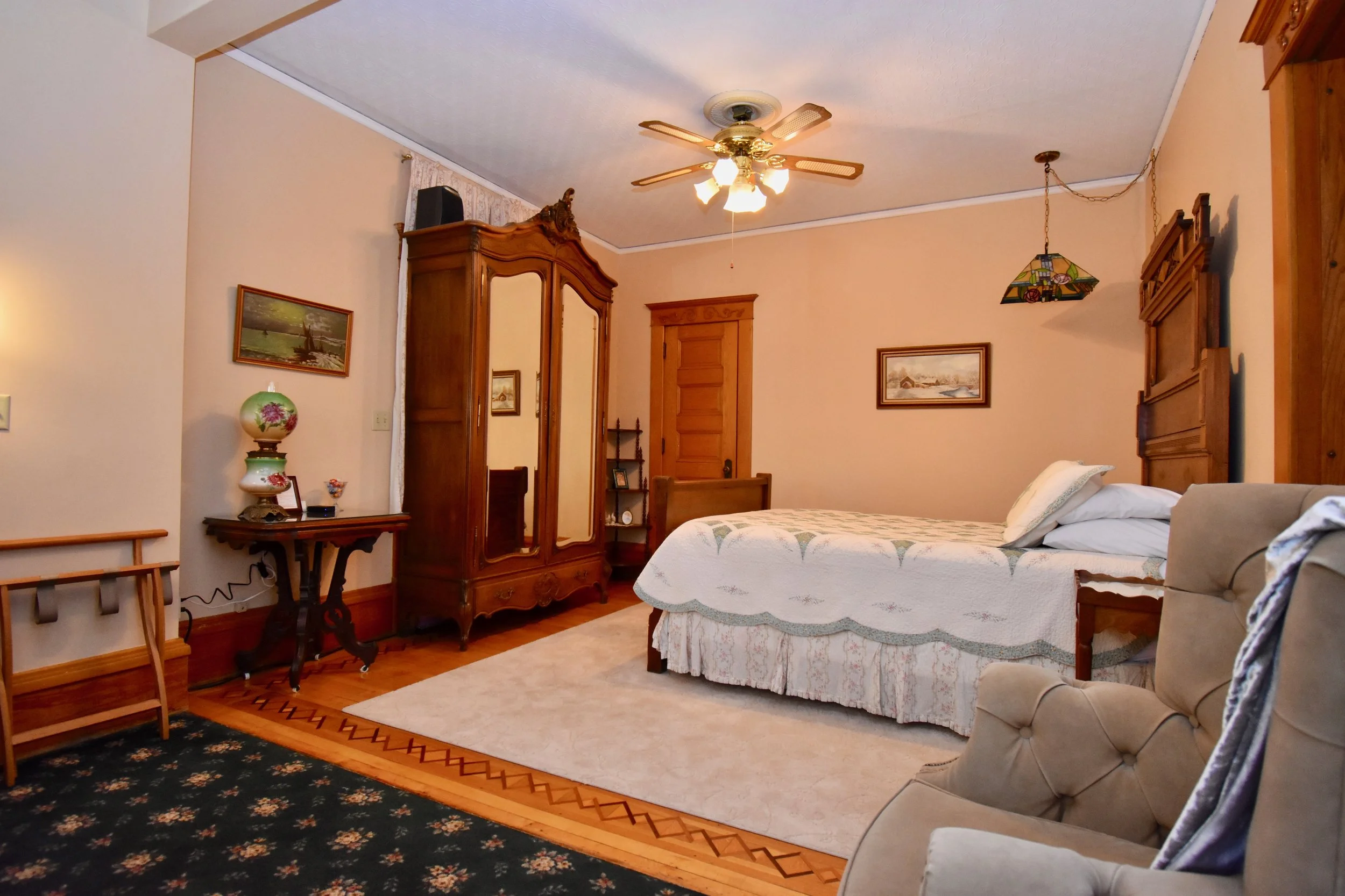 Queen Bed with Large Armoire containing 40" Smart TV and small refrigerator