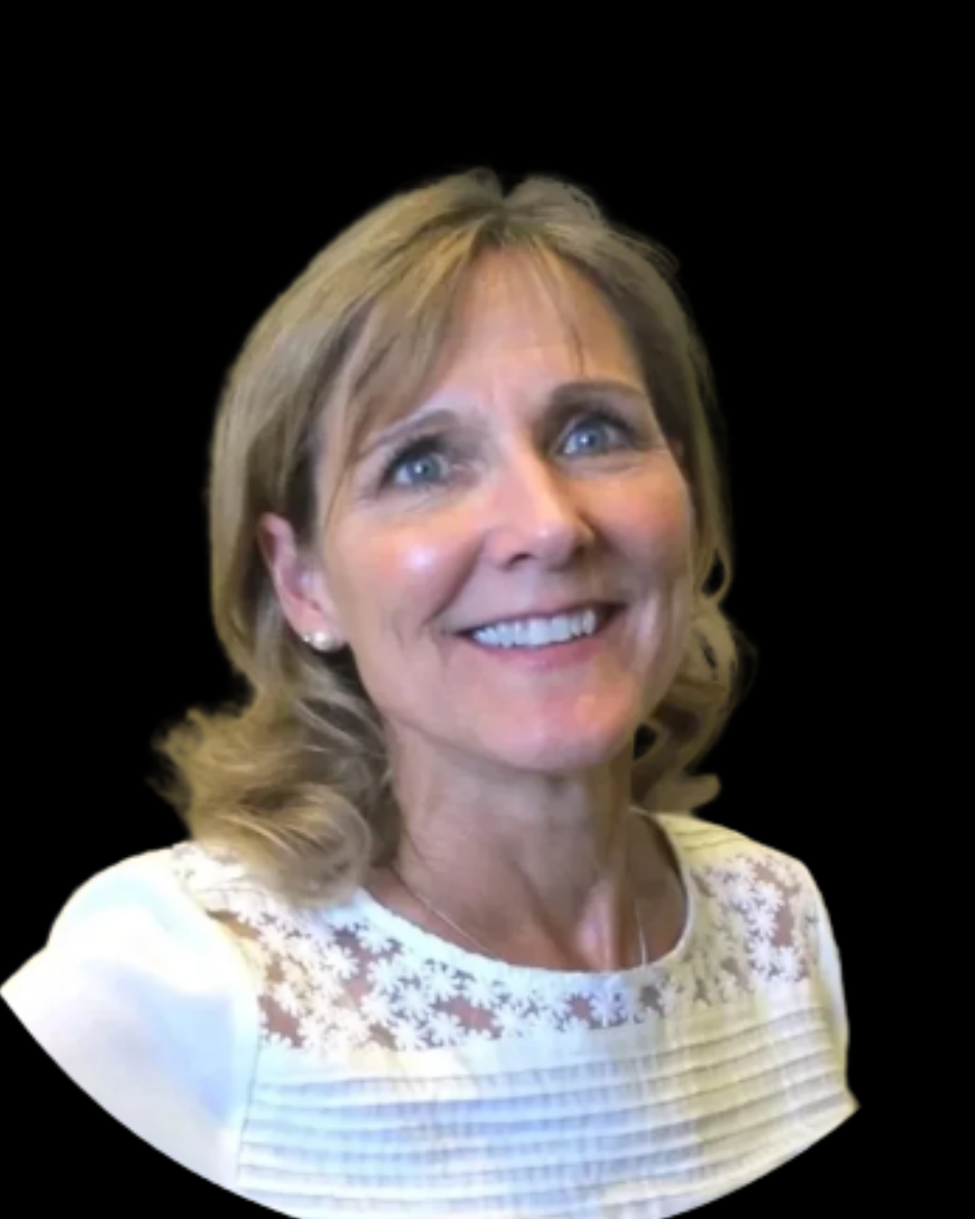 A woman with blonde, wavy hair, blue eyes, smiling, wearing a white lace and striped top, against a black background.