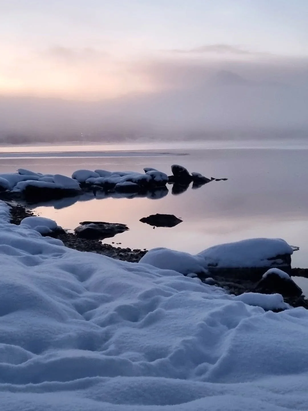 Oterspor ved en fjord som snart fryser til.
Kanskje gjemmer dyret seg i naustet, rett bak meg.
Lytter til tobeinte steg i t&oslash;rr sn&oslash; mens det lille hjertet banker.
Jeg lytter ogs&aring;.
Sj&oslash;en lager sm&aring; knepp og duver mot ise