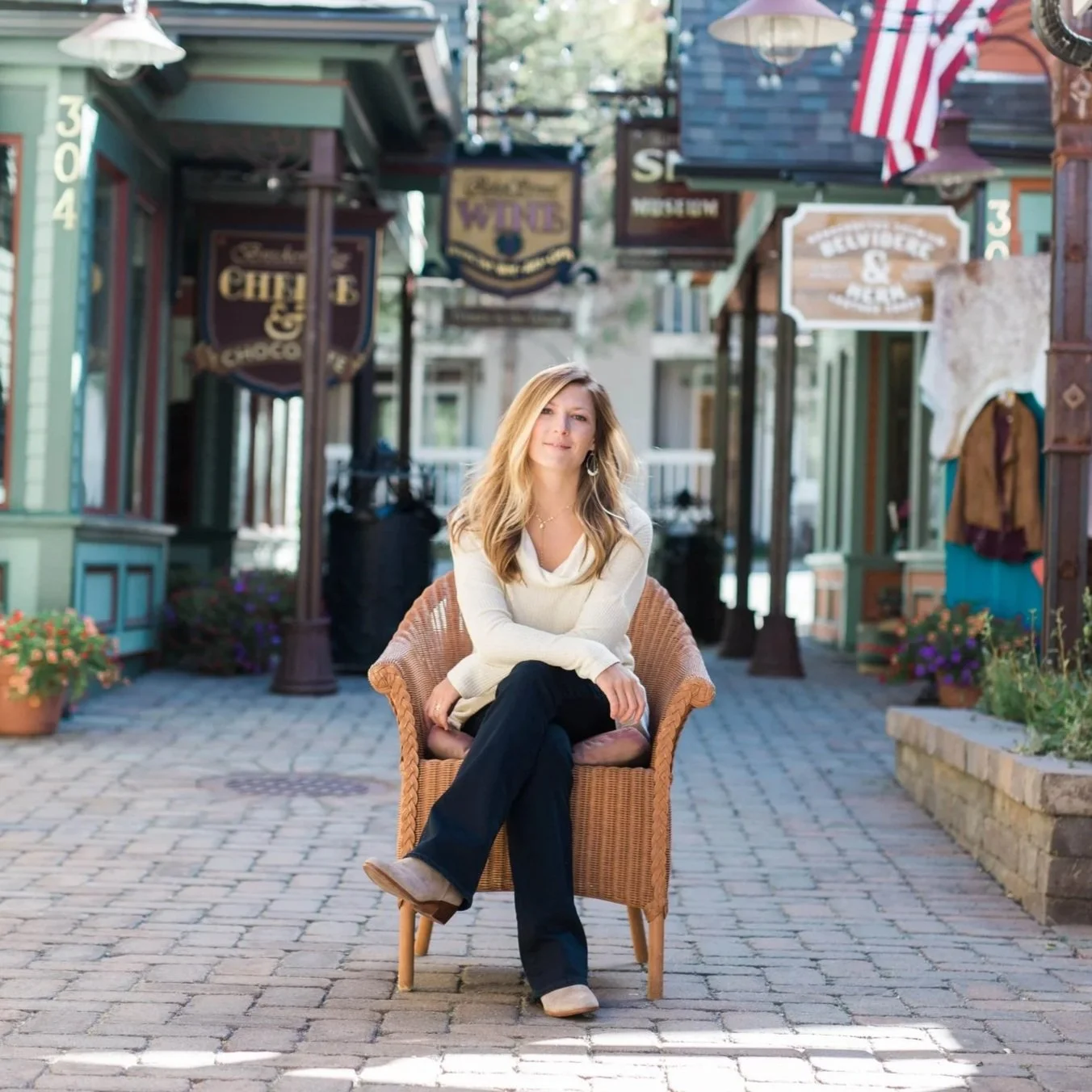 Photo of me, Allie Horner sitting in chair in pedestrian walking alleyway with small shops