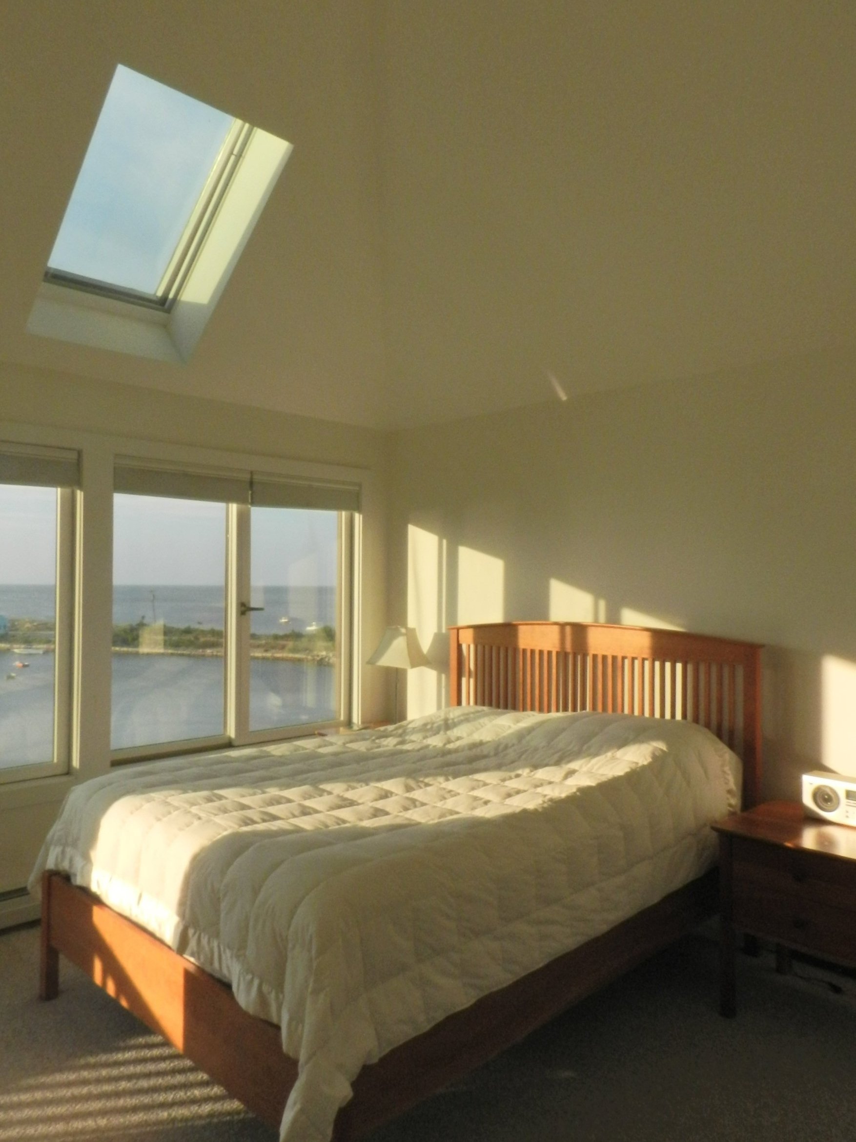  The upstairs master bedroom features a Chilton bed, a smart thermostat with ductless A/C, and a skylight with remote-controlled open/close and shade. 