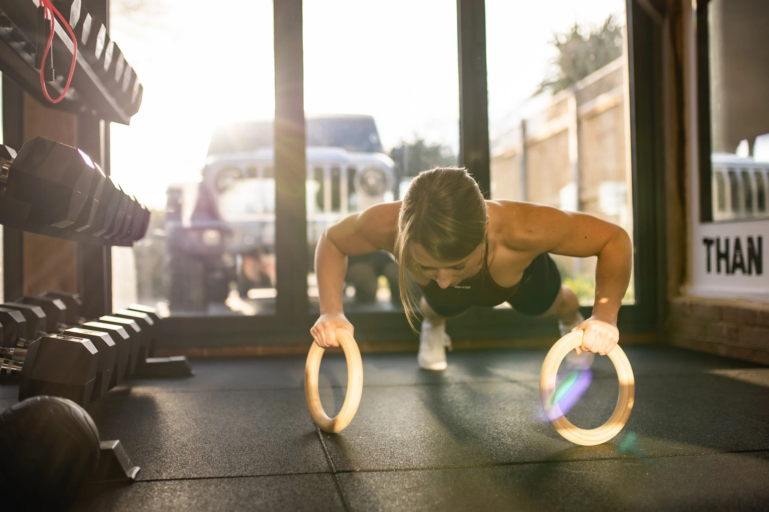 personal trainer doing ring press ups.