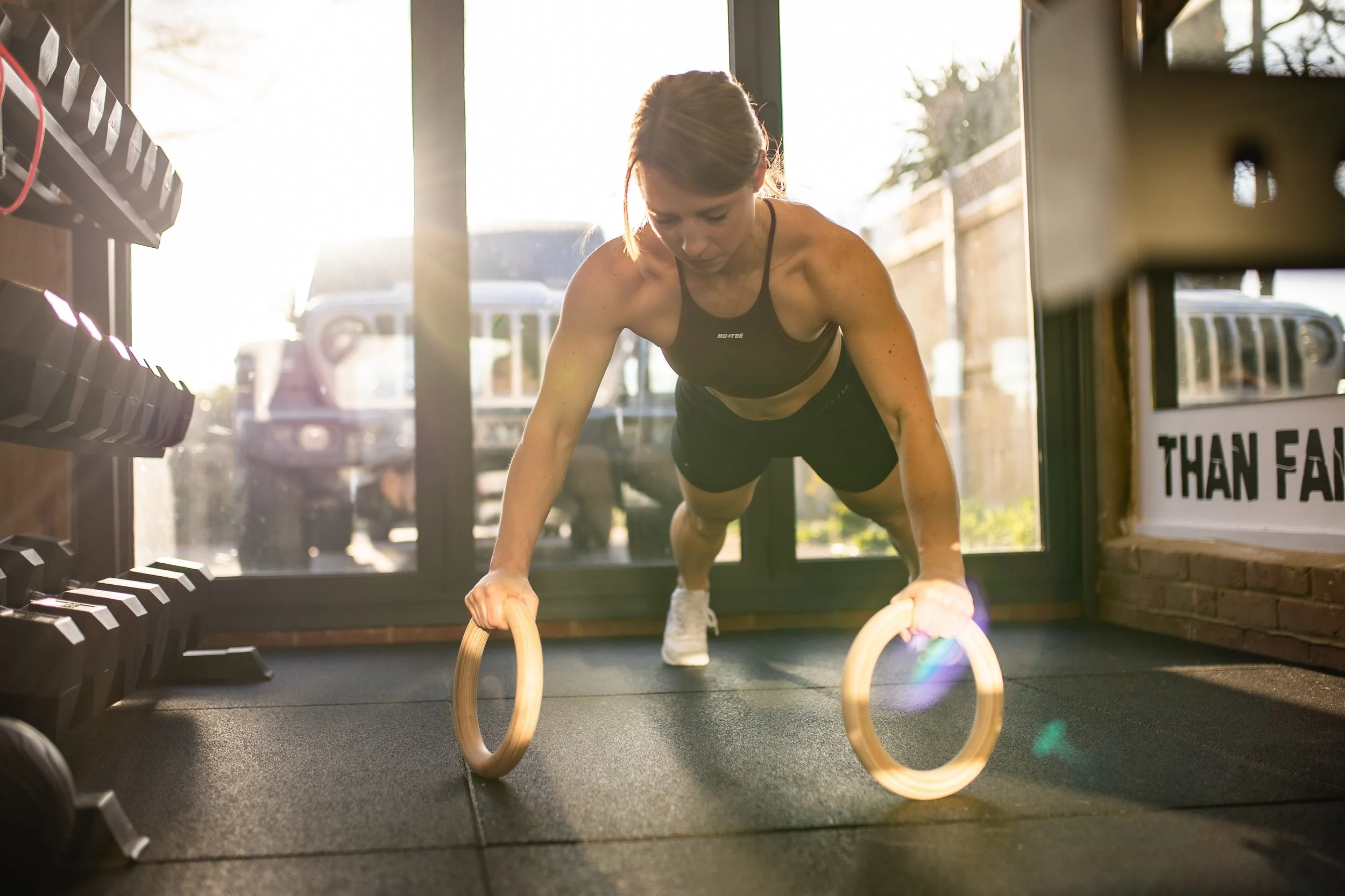 personal trainer preparing to do a ring press up in a gym