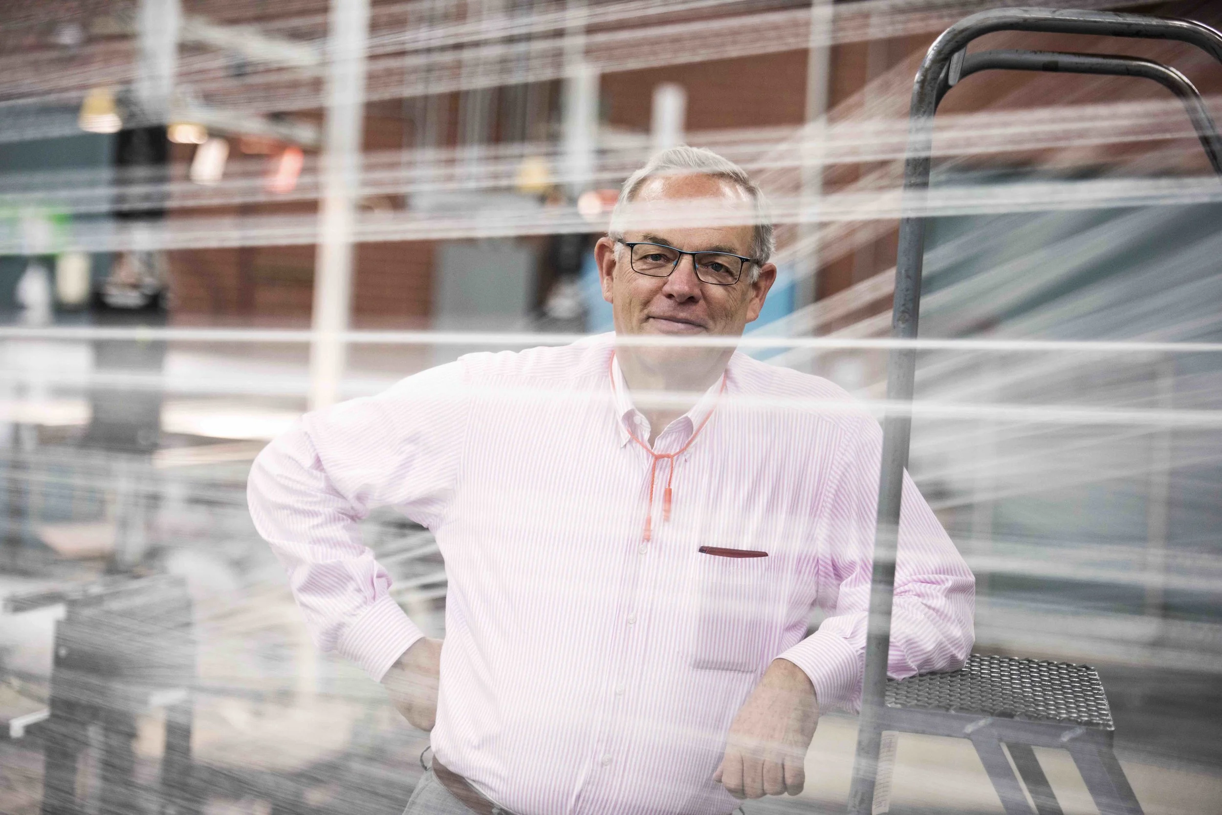 Fairystone Fabrics President Jim Bryan standing beside factory equipment